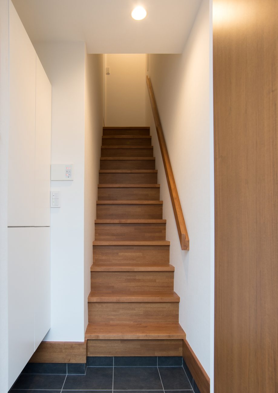木の手すりが取り付けられたシンプルな箱型階段・デザイン住宅 注文住宅・デザイン住宅建築実例_『CASE523 くのじのいえ』_玄関