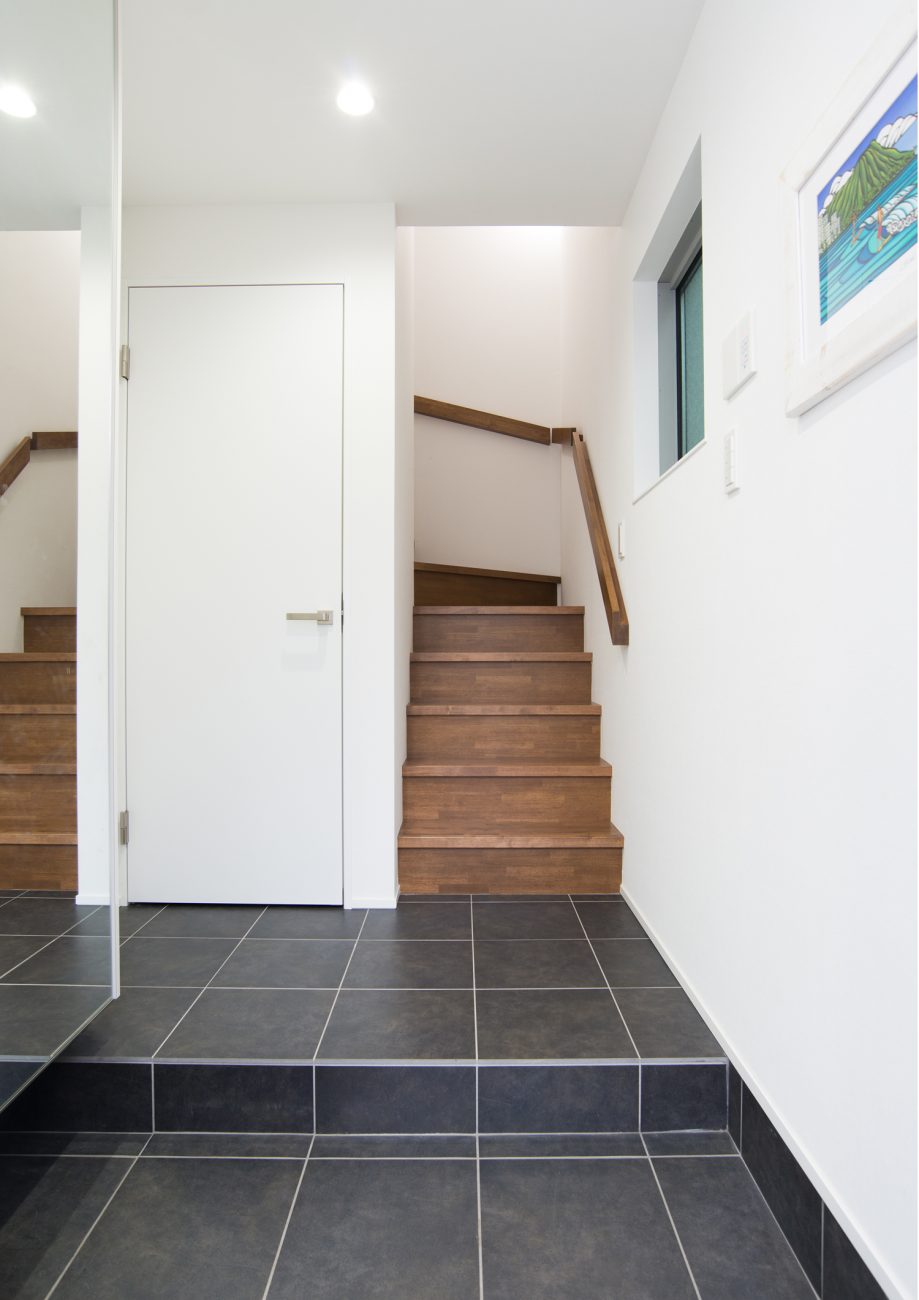 黒いタイルのフロアから木の箱型階段へと繋がる室内・デザイン住宅 注文住宅・デザイン住宅建築実例_『CASE523 くのじのいえ』_玄関