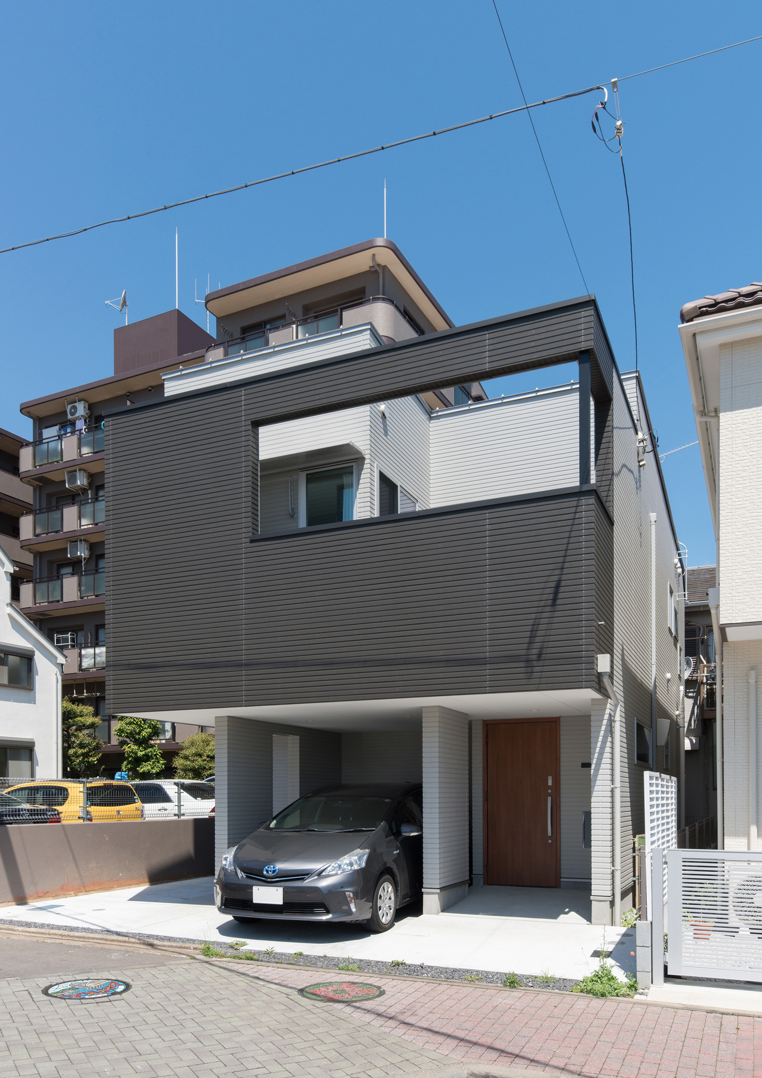 インナーガレージ付きのモノトーンの外壁の家・デザイン住宅 注文住宅・デザイン住宅建築実例_『CASE524 Enclose Terrace』_外観