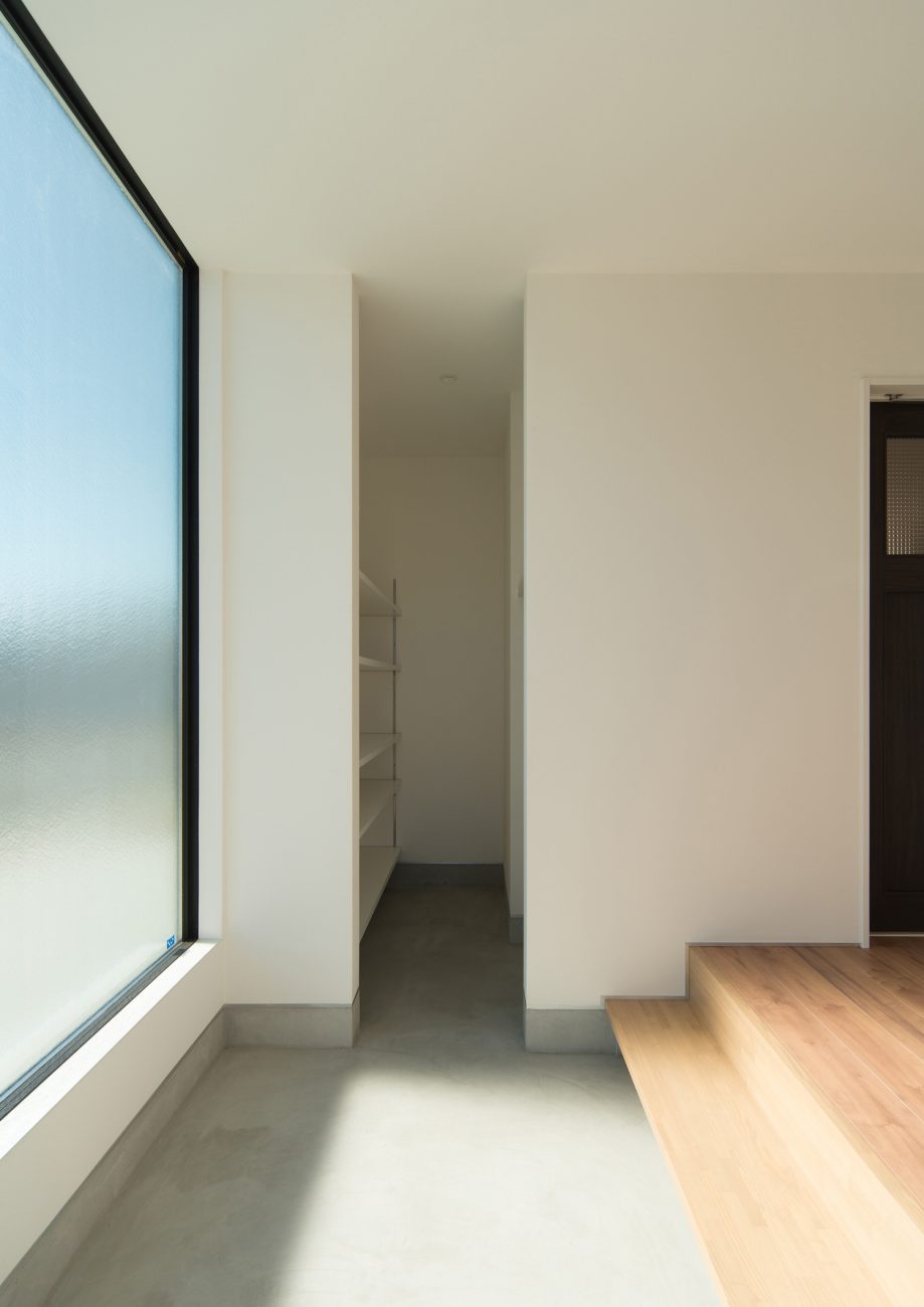 大きな窓が取り付けられている明るいモルタルの玄関・デザイン住宅 注文住宅・デザイン住宅建築実例_『CASE526 Two-tone』_玄関