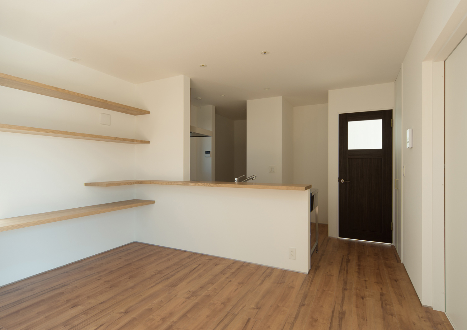 腰壁に木のカウンターを取り付けたシンプルで生活感の少ないLDK・デザイン住宅 注文住宅・デザイン住宅建築実例_『CASE526 Two-tone』_キッチン