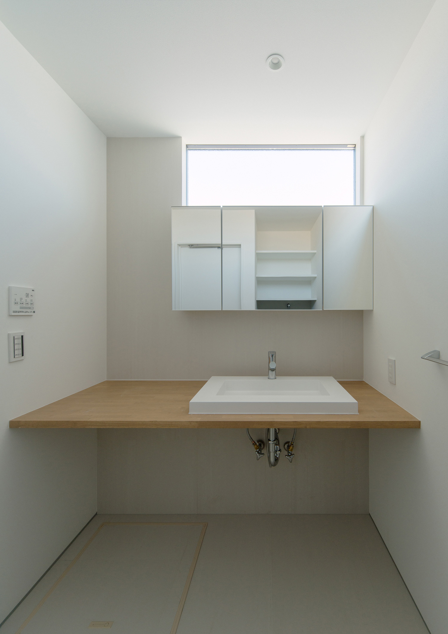 スリット窓から光が入る、木の洗面台のシンプルな洗面所・デザイン住宅 注文住宅・デザイン住宅建築実例_『CASE526 Two-tone』_浴室・洗面所