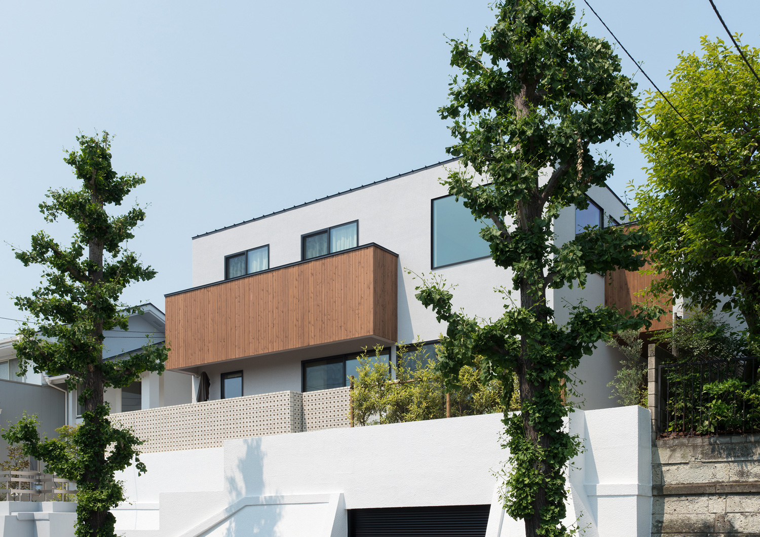 家の前に木が植えられた高台の上にある家・デザイン住宅 注文住宅・デザイン住宅建築実例_『CASE530 ミクストメディア』_外観