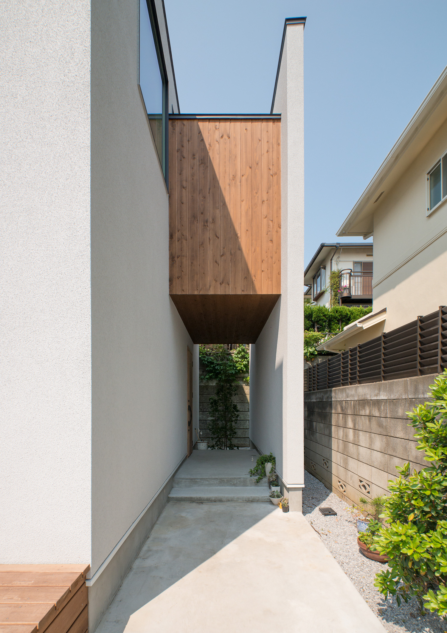 白い目隠し壁や木のアクセントがあるシンプルでおしゃれな玄関・デザイン住宅 注文住宅・デザイン住宅建築実例_『CASE530 ミクストメディア』_外観