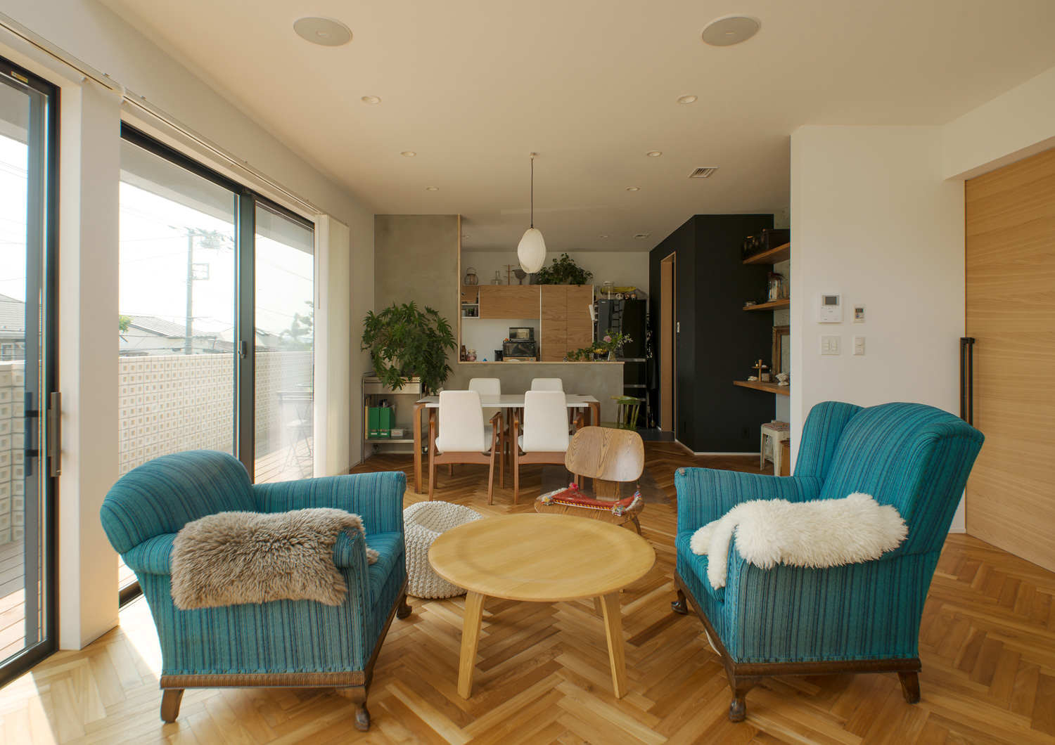 レトロなデザインのソファーを置いたヘリンボーン床のおしゃれなLDK・デザイン住宅 注文住宅・デザイン住宅建築実例_『CASE530 ミクストメディア』_LDK