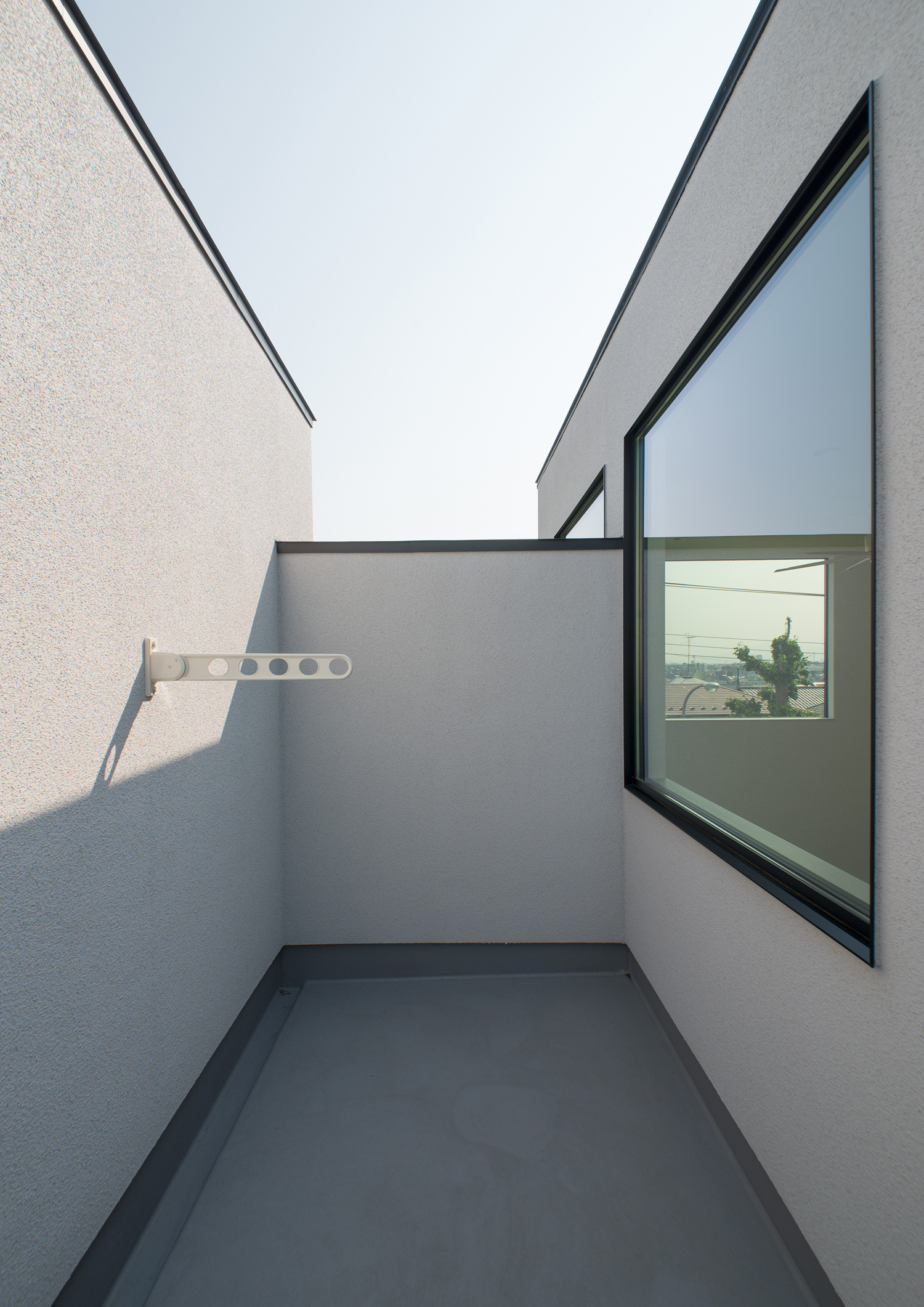 目隠し壁に囲まれた物干し金具があるプライバシー性の高いバルコニー・デザイン住宅 注文住宅・デザイン住宅建築実例_『CASE530 ミクストメディア』_テラス・バルコニー