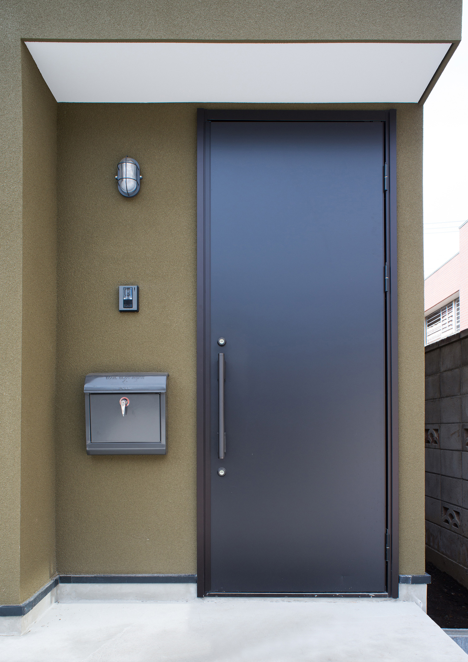 カーキの外壁に金属製の玄関扉が取り付けられたインダストリアルな玄関・デザイン住宅 注文住宅・デザイン住宅建築実例_『CASE531 素地』_外観