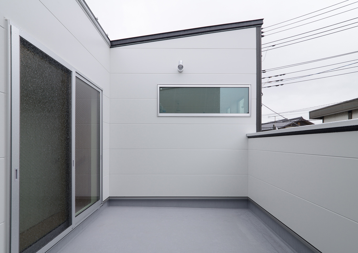 白い目隠し壁が取り付けられたバルコニー・デザイン住宅 注文住宅・デザイン住宅建築実例_『CASE535 ドマ＋LDK』_テラス・バルコニー