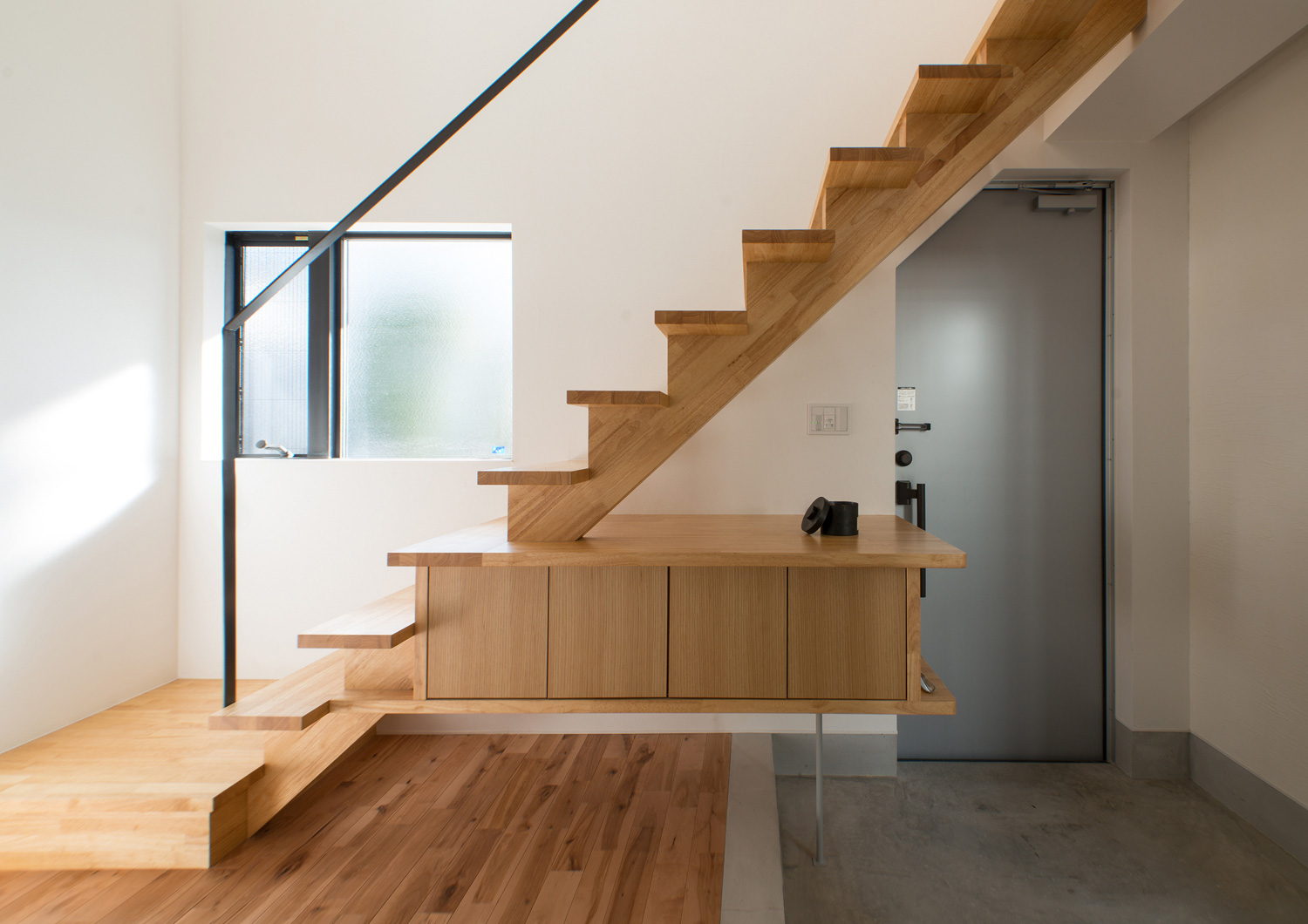 玄関の上を横切るような木のスケルトン階段と浮いたデザインの木の収納・デザイン住宅 注文住宅・デザイン住宅建築実例_『CASE541 寄棟天井のある家』_階段