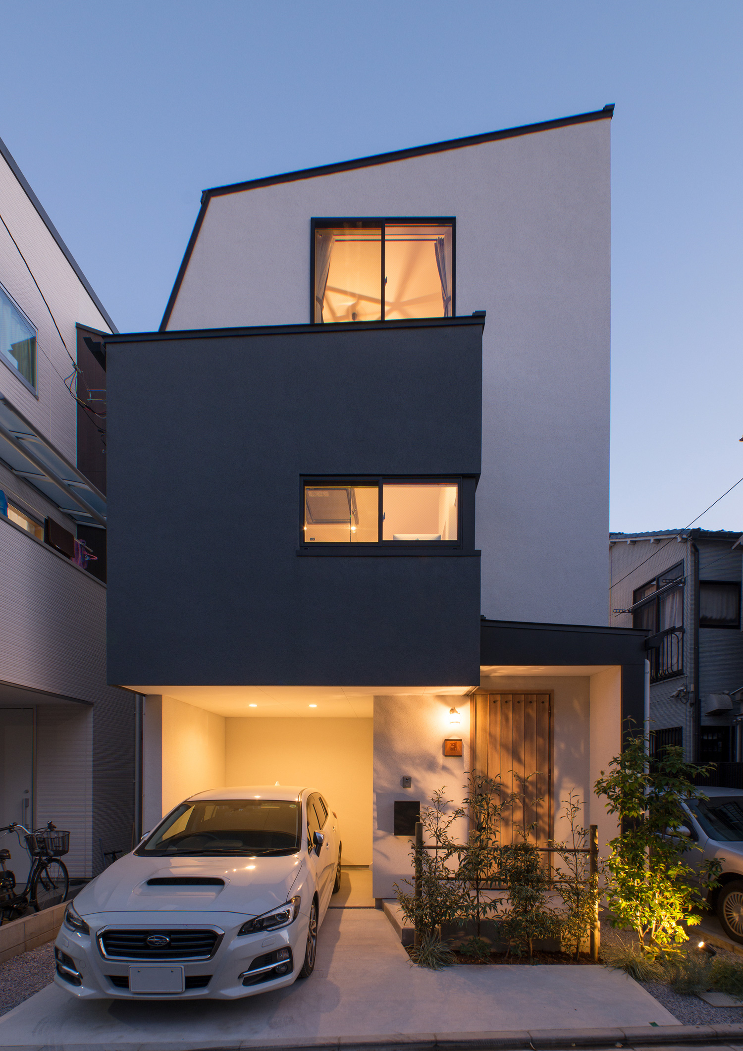 ガレージの中や玄関アプローチに照明が取り付けられた三階建ての家・デザイン住宅 注文住宅・デザイン住宅建築実例_『CASE547 移ろいの家』_外観