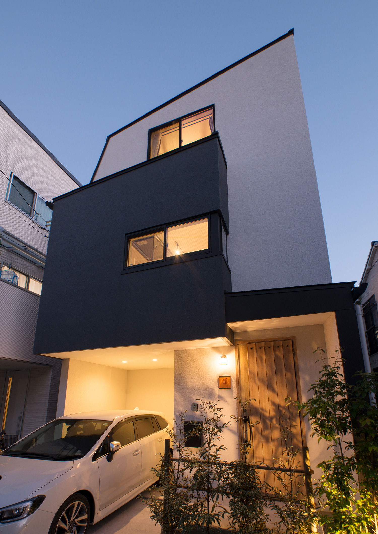 植栽がライトアップされた木製の玄関扉がある家の外観・デザイン住宅 注文住宅・デザイン住宅建築実例_『CASE547 移ろいの家』_外観