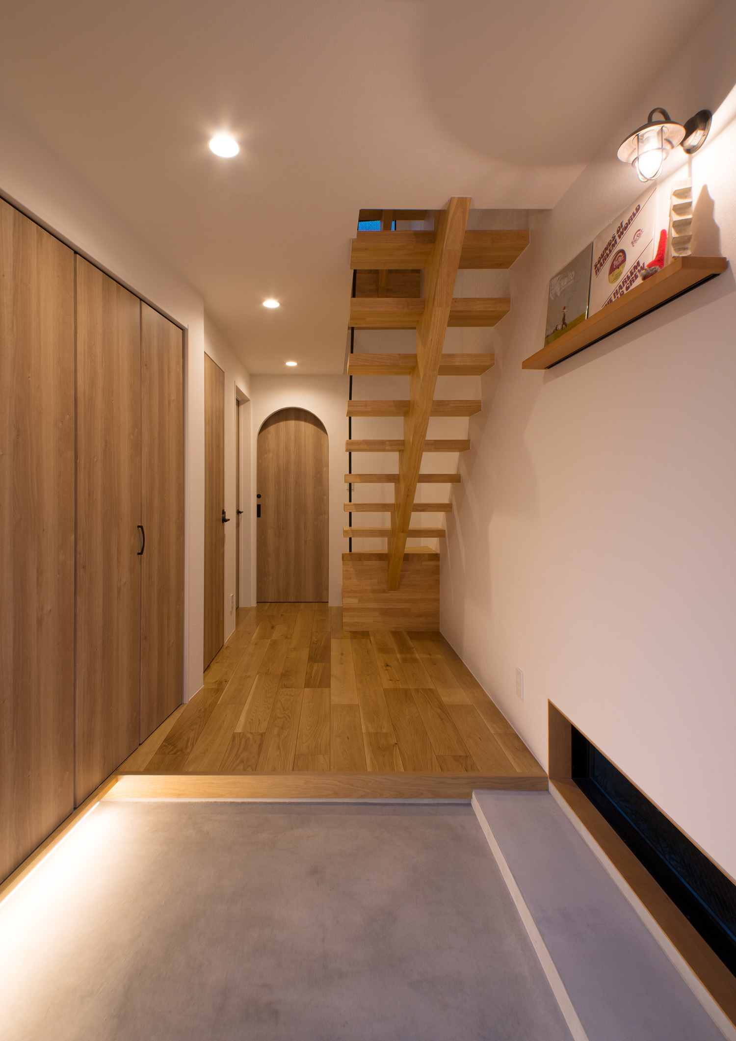 足元に間接照明を設け、壁には照明付きの飾り棚を取り付けたおしゃれな玄関・デザイン住宅 注文住宅・デザイン住宅建築実例_『CASE547 移ろいの家』_玄関