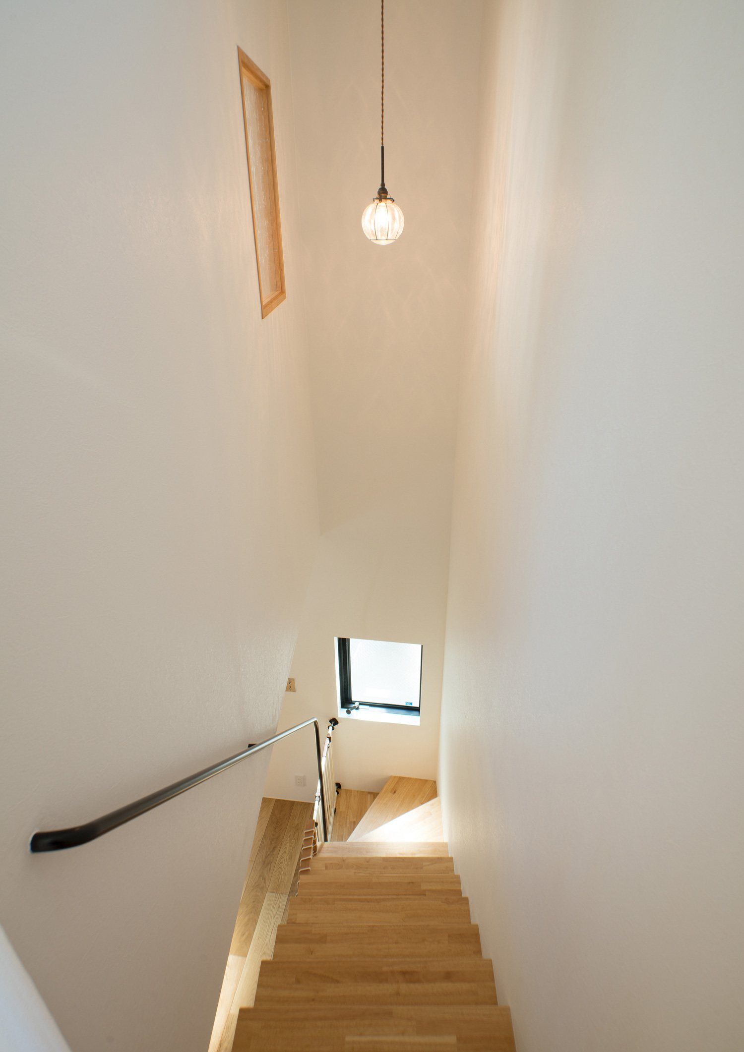 丸いペンダントライトが取り付けられた木製のスケルトン階段がある階段室・デザイン住宅 注文住宅・デザイン住宅建築実例_『CASE547 移ろいの家』_階段