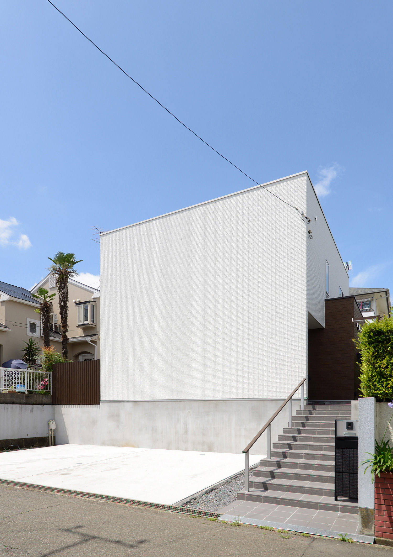 コンクリートの階段アプローチがある窓のない白い外壁の家の外観・デザイン住宅 注文住宅・デザイン住宅建築実例_『CASE561 TOHFU-HOUSE』_外観