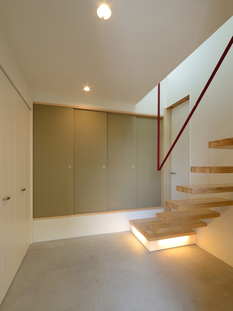 スケルトン階段の下に照明を取り付けたモルタルのおしゃれな玄関・デザイン住宅 注文住宅・デザイン住宅建築実例_『CASE561 TOHFU-HOUSE』_玄関