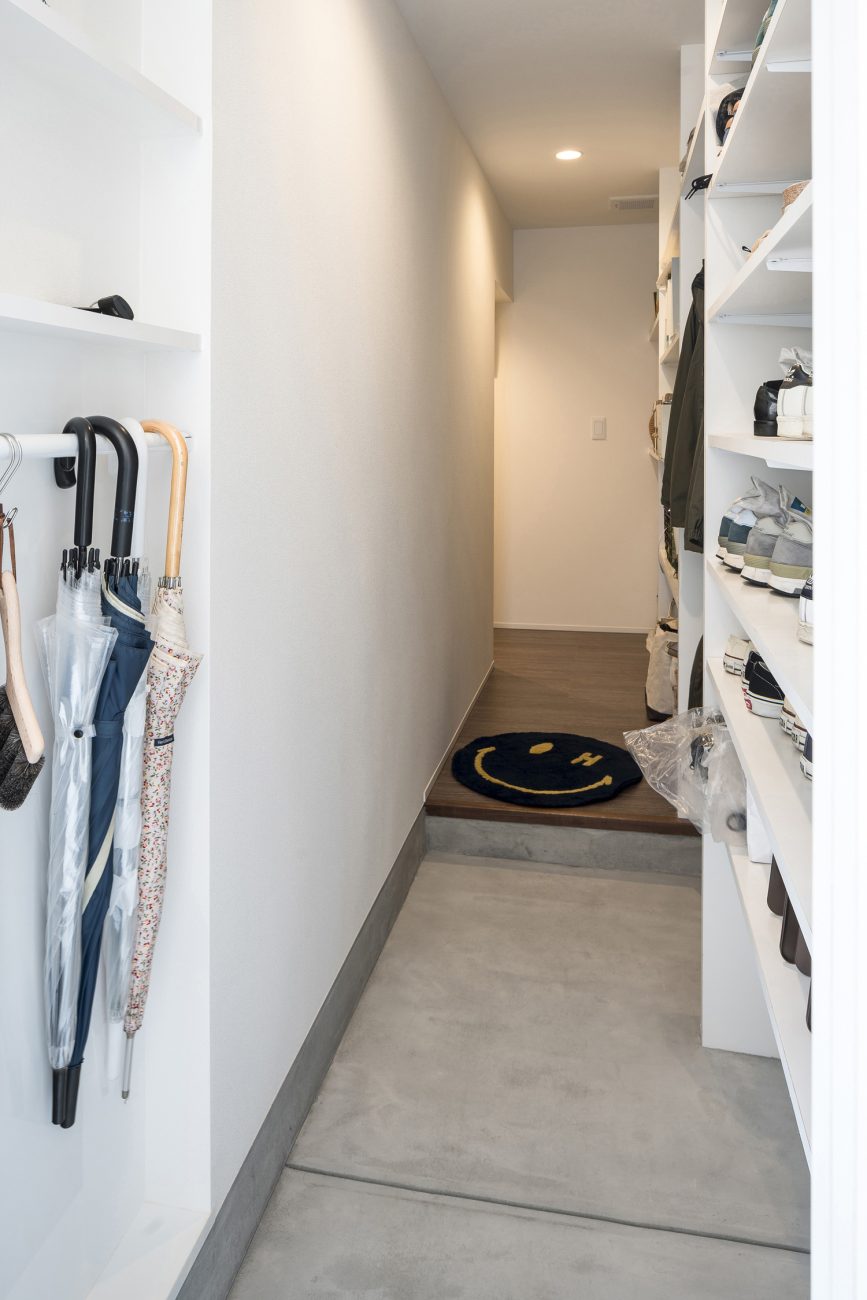 壁にシューズボックスや傘を掛けるスペースを設けたモルタルの玄関・デザイン住宅 注文住宅・デザイン住宅建築実例_『CASE563 pocket』_玄関