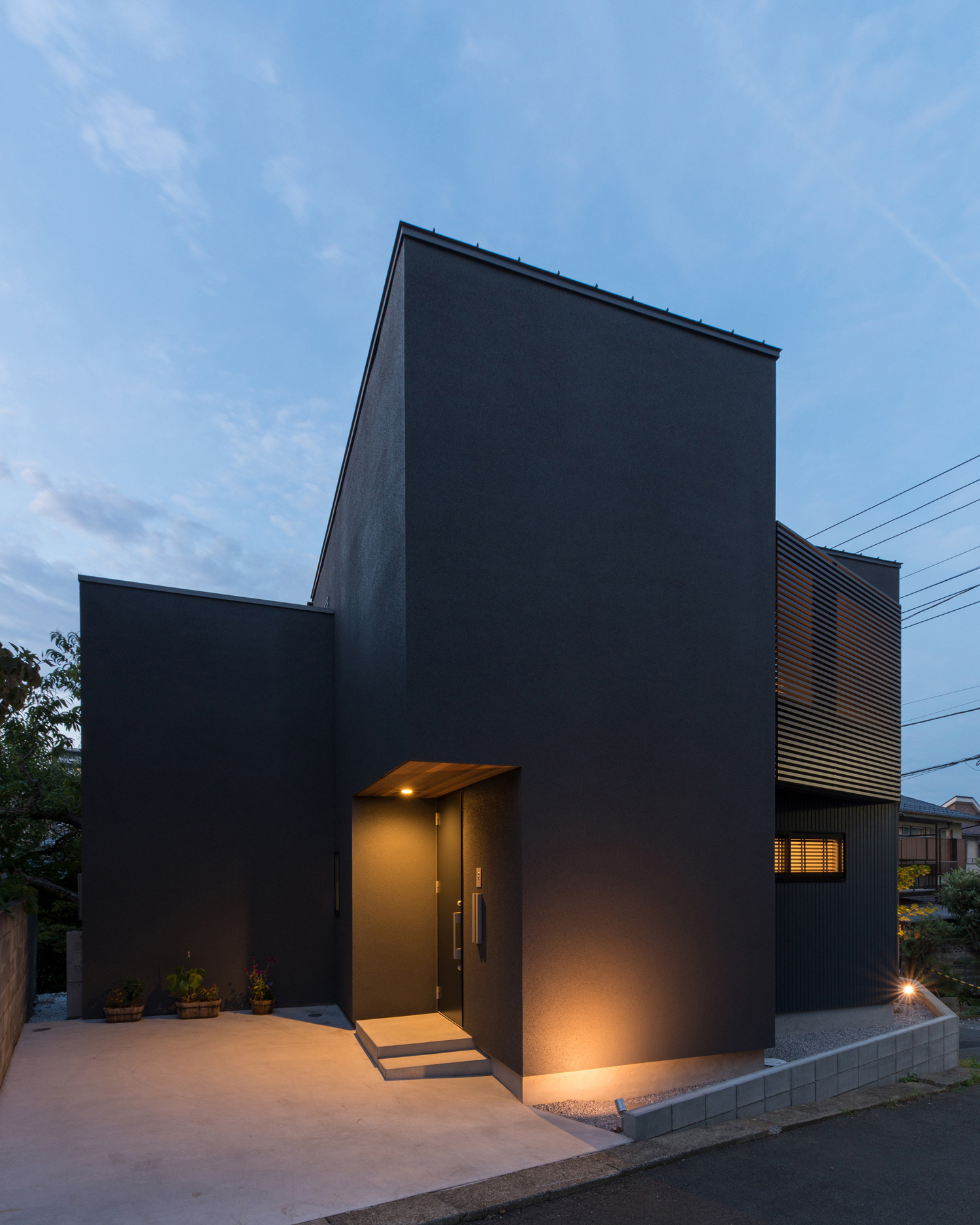 地面に埋め込まれた照明や軒天井の照明に照らされる美術館のような家の外観・デザイン住宅 注文住宅・デザイン住宅建築実例_『CASE564 高尾の家』_外観