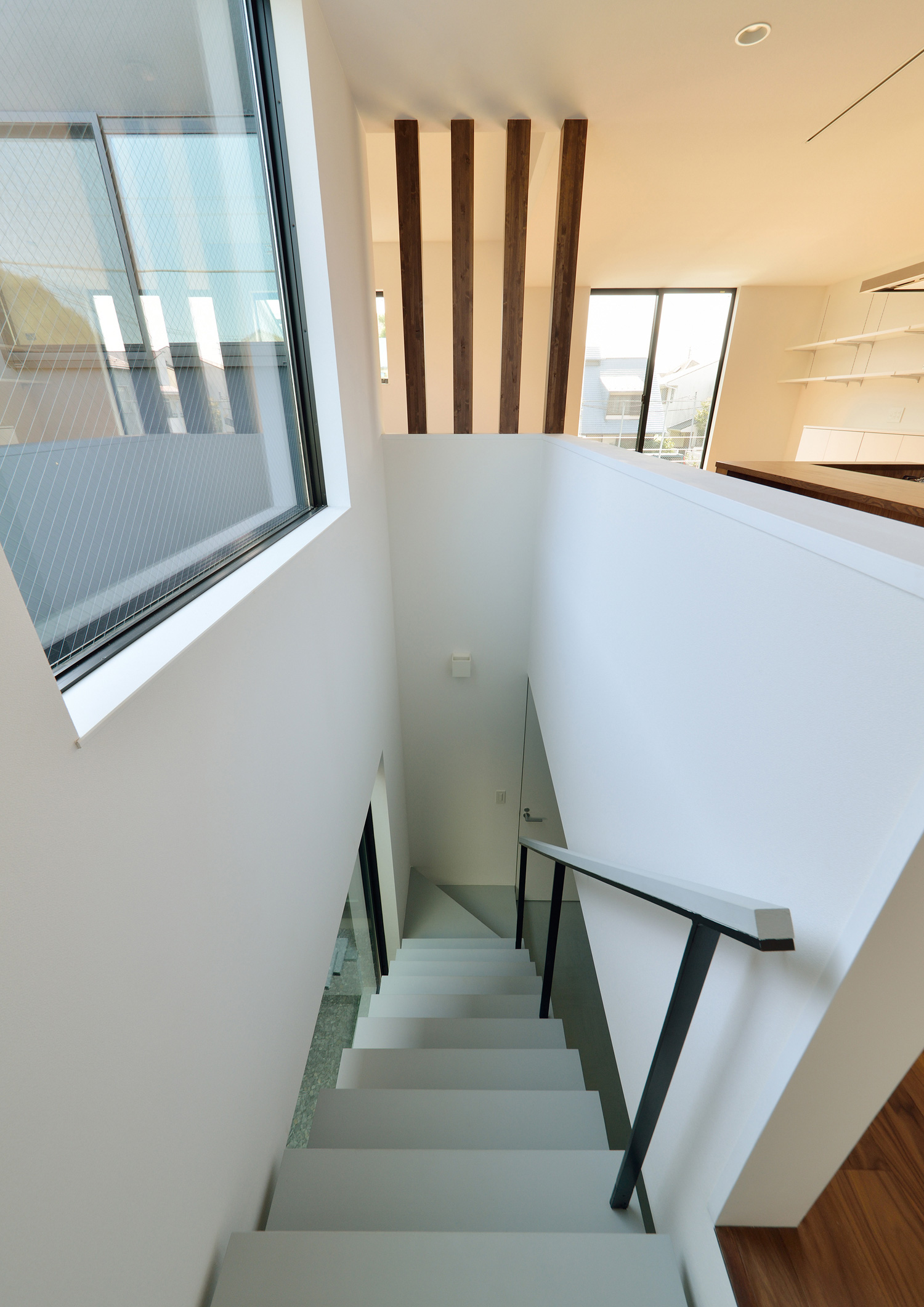 窓のある壁に面したグレーの階段・デザイン住宅 注文住宅・デザイン住宅建築実例_『CASE566 拡がりを内包する黒庭』_階段