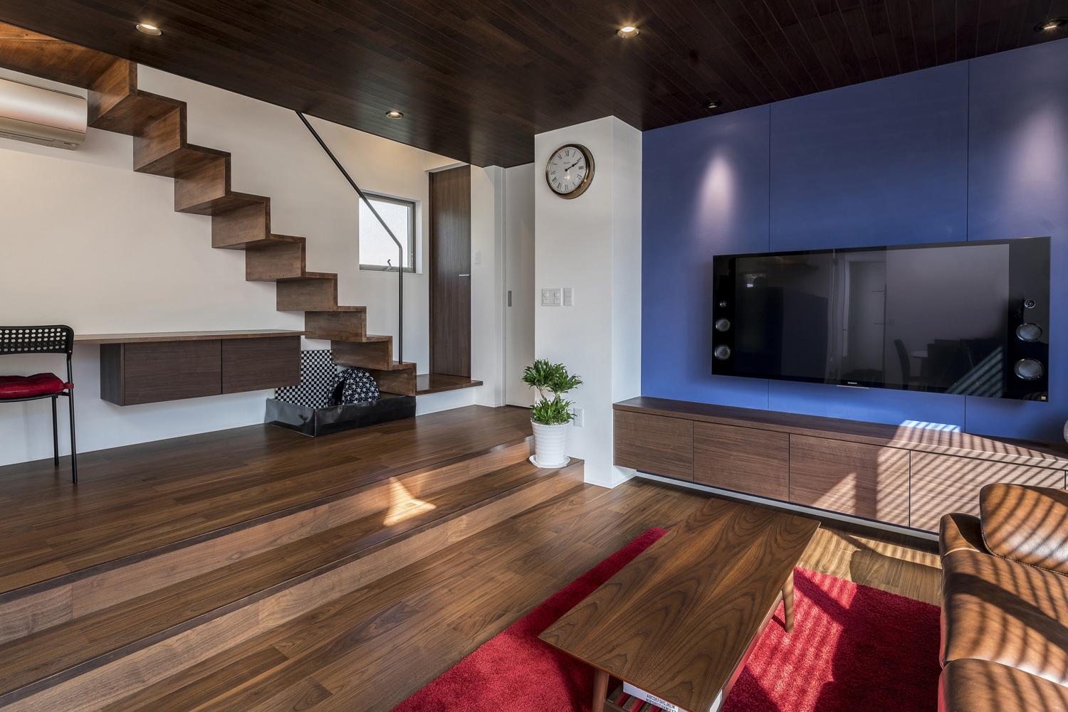 青いアクセントクロスにスピーカー付きのテレビを掛けたリビングイン階段のあるLDK・デザイン住宅 注文住宅・デザイン住宅建築実例_『CASE567 lokki』_LDK