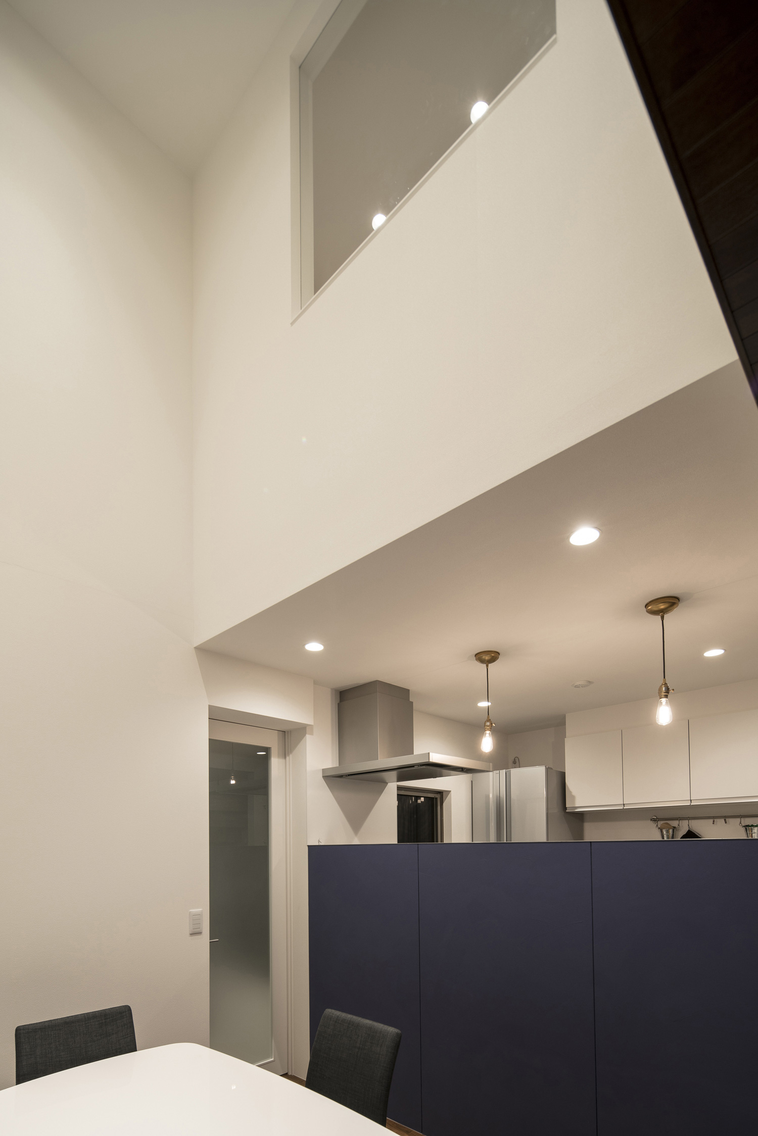 吹き抜け部分に室内窓を設けた、青い腰壁付きのキッチンがあるLDK・デザイン住宅 注文住宅・デザイン住宅建築実例_『CASE567 lokki』_LDK