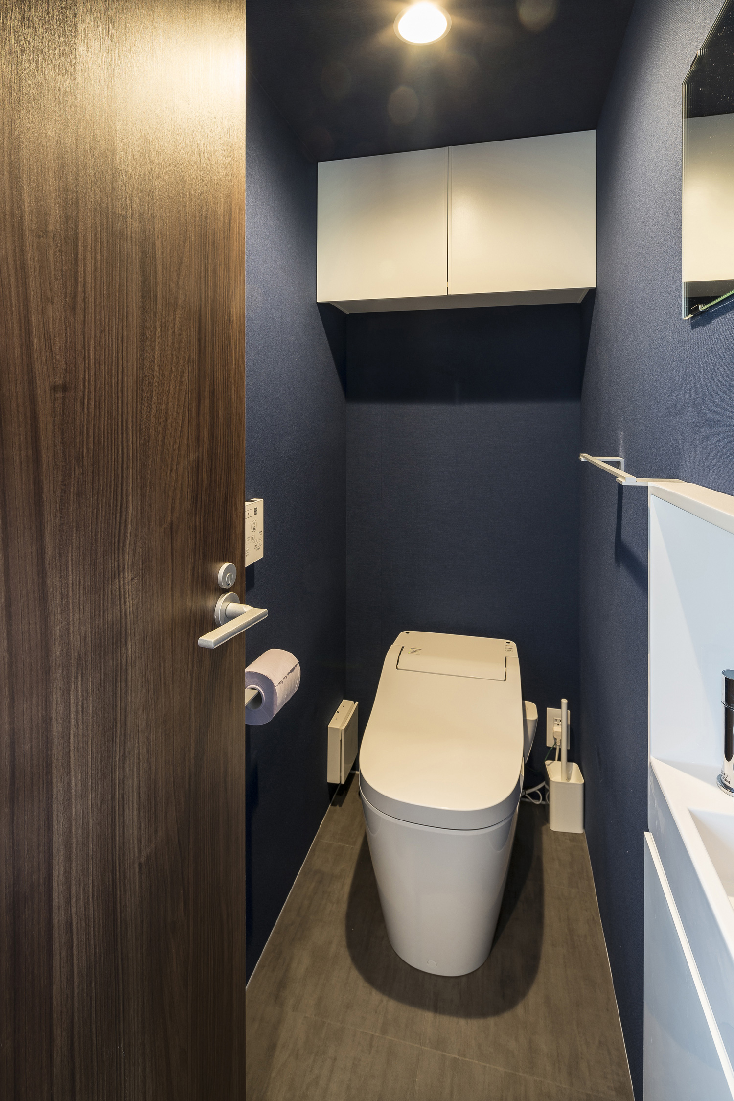 頭上に白い収納を取り付けた青いクロスのトイレ・デザイン住宅 注文住宅・デザイン住宅建築実例_『CASE567 lokki』_トイレ