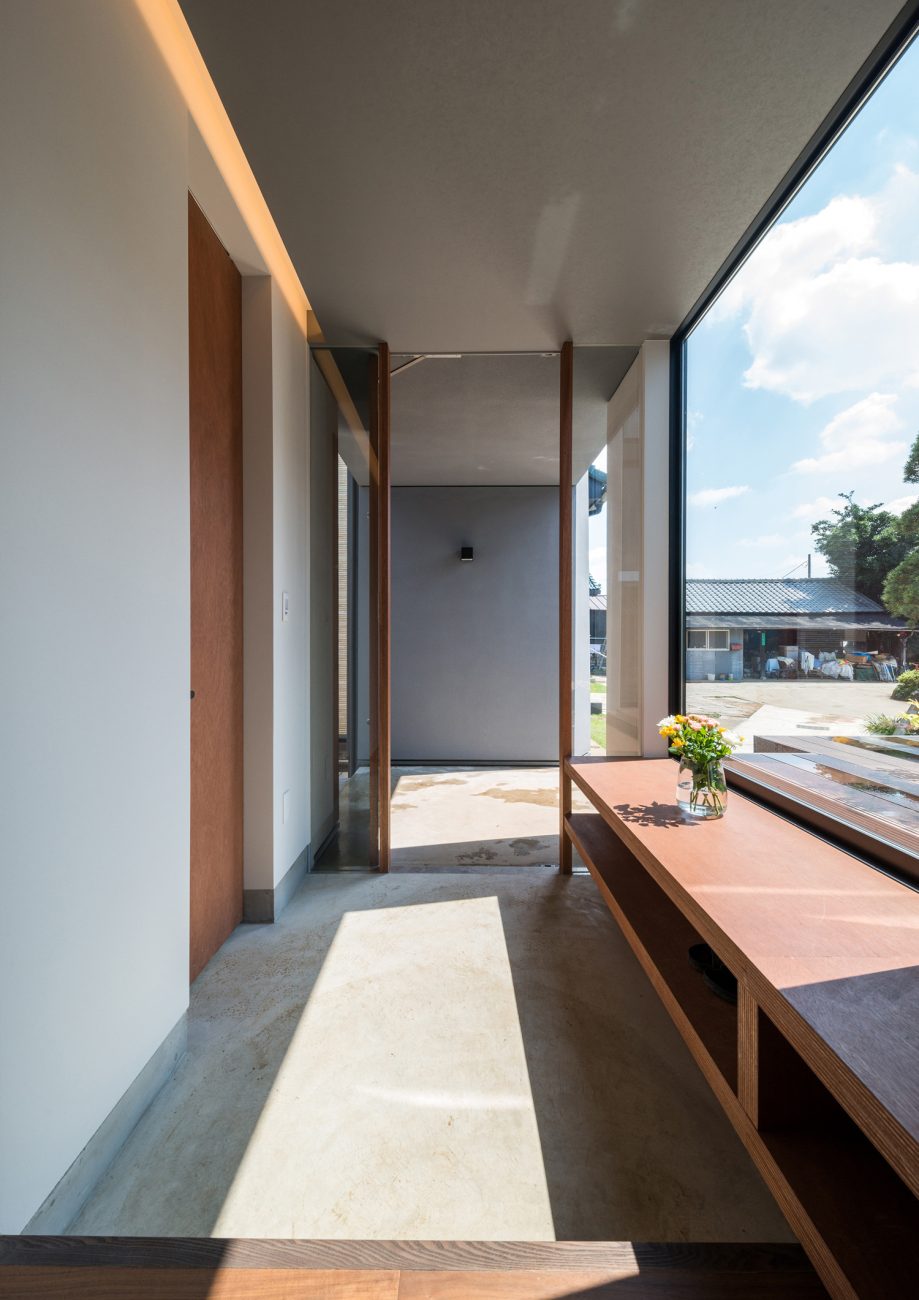 窓際に造作ベンチを置いたモルタルの玄関・デザイン住宅 注文住宅・デザイン住宅建築実例_『CASE573 次代の家』_玄関