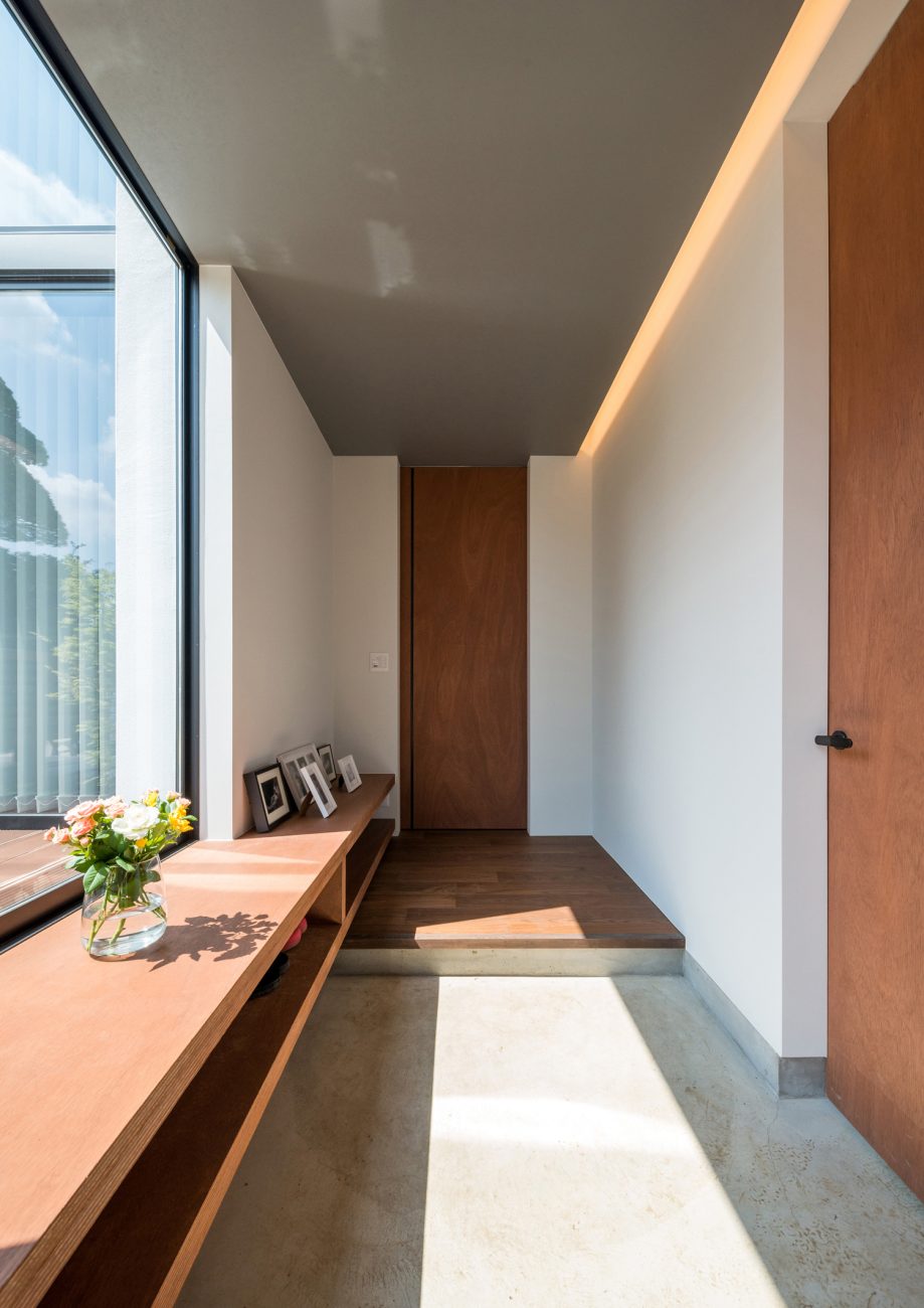 テラスに面した大きな窓がある明るいモルタルの玄関・デザイン住宅 注文住宅・デザイン住宅建築実例_『CASE573 次代の家』_玄関