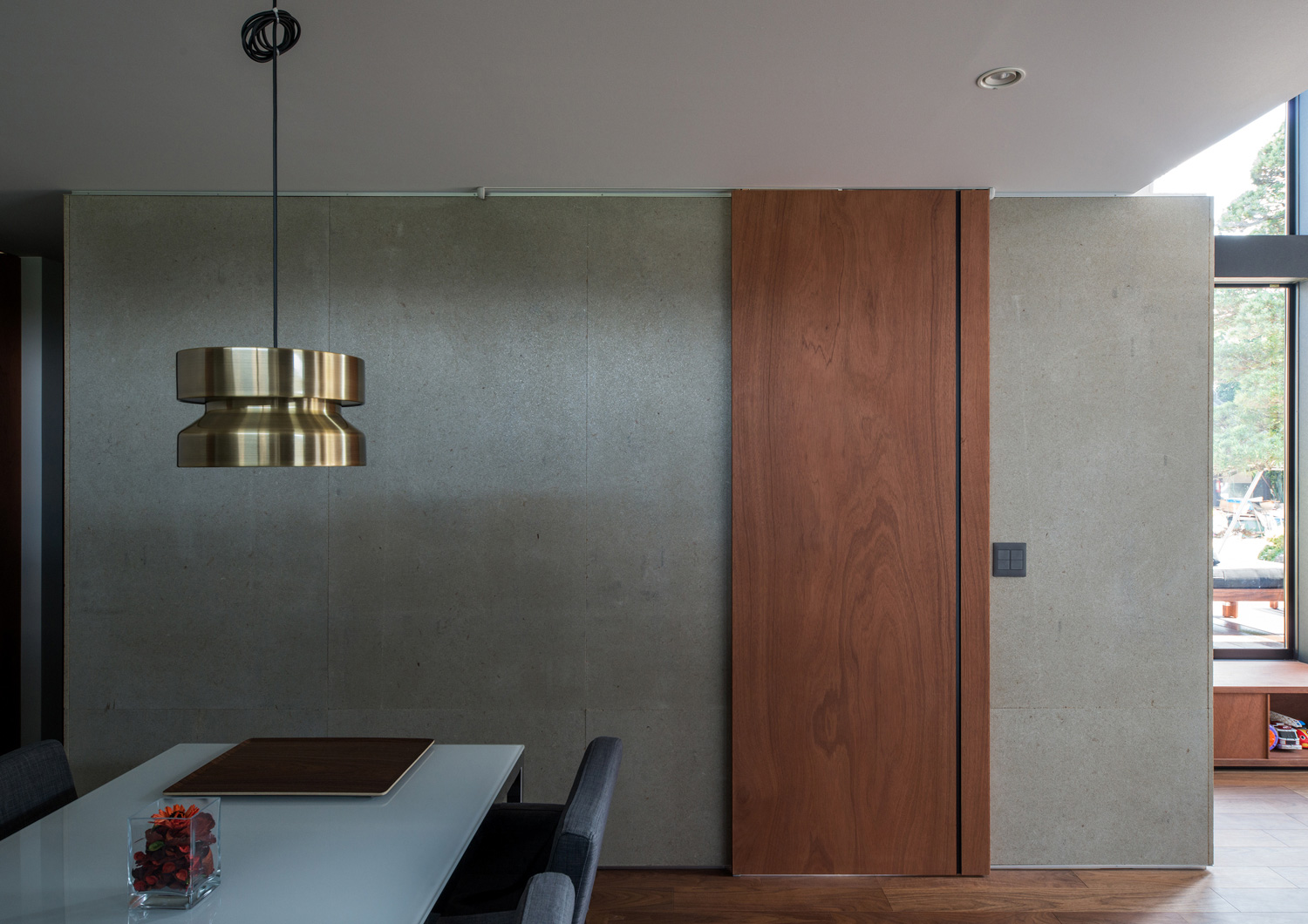 コンクリートの壁に木の引き戸を取りつけたLDK・デザイン住宅 注文住宅・デザイン住宅建築実例_『CASE573 次代の家』_LDK