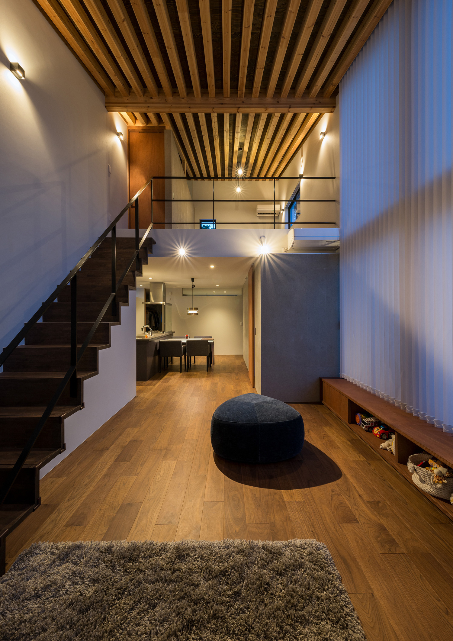 壁に間接照明が取り付けられた吹き抜けのLDK・デザイン住宅 注文住宅・デザイン住宅建築実例_『CASE573 次代の家』_LDK