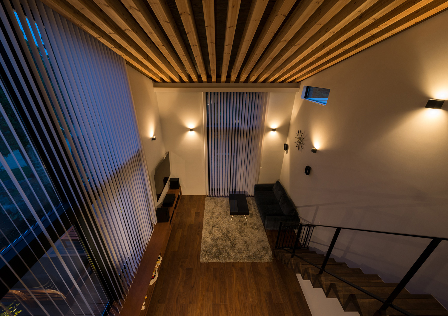 壁に間接照明を取り付けたルーバー天井のLDKをロフトから見下ろした様子・デザイン住宅 注文住宅・デザイン住宅建築実例_『CASE573 次代の家』_LDK