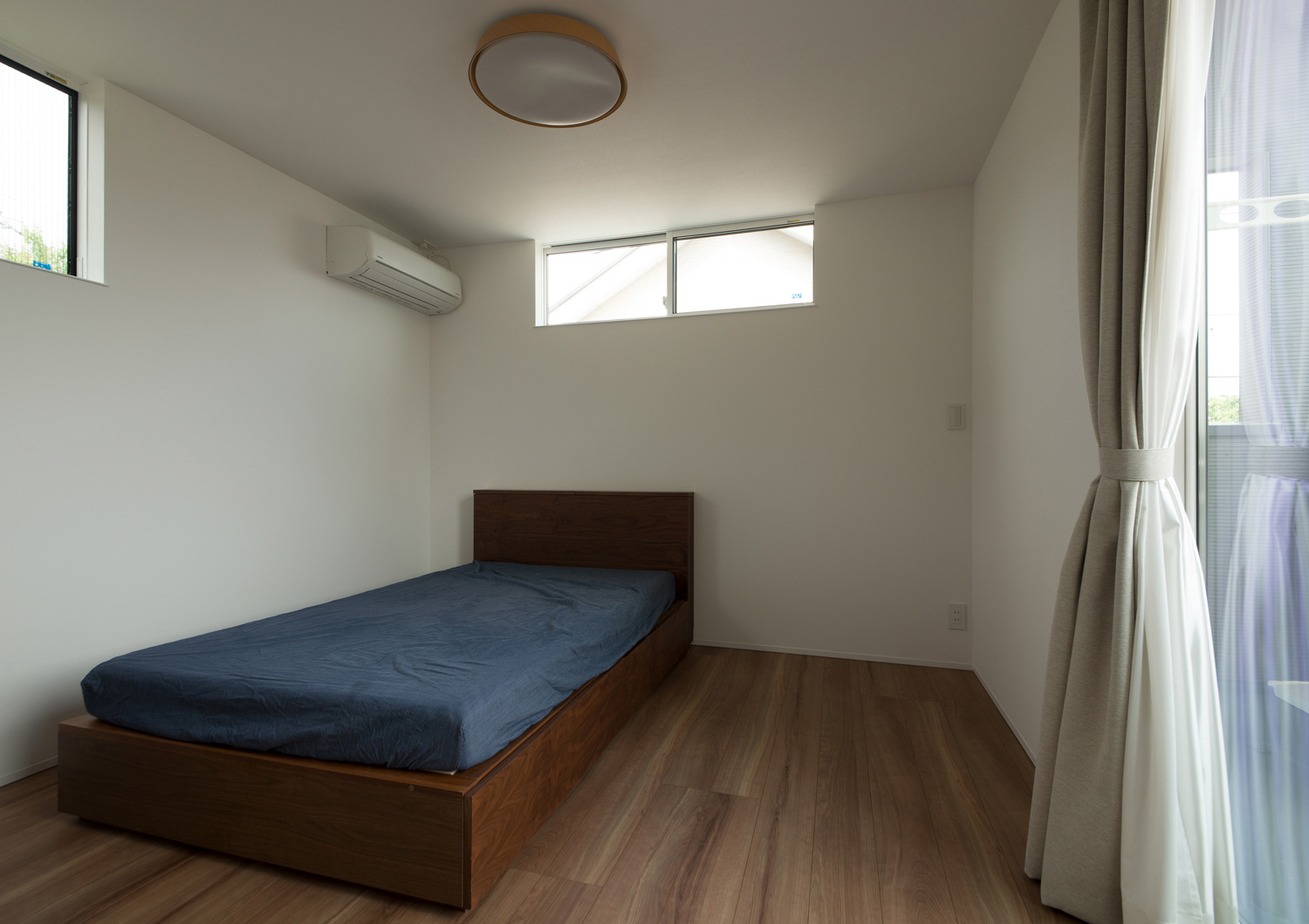 シングルベッドを一台置いた三方向に窓がある寝室・デザイン住宅 注文住宅・デザイン住宅建築実例_『CASE575 緑を楽しむ家』_寝室