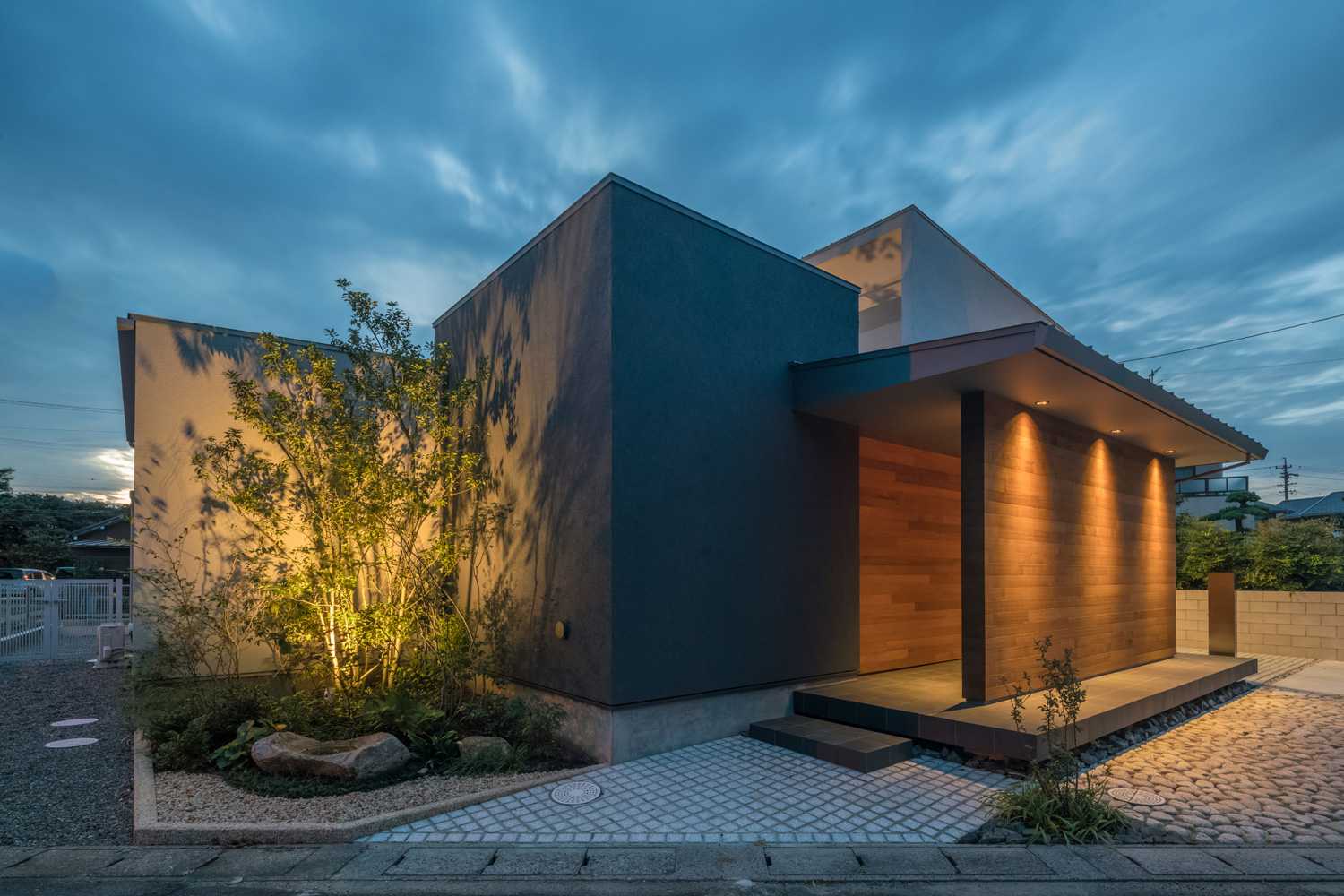 シンボルツリーや目隠し壁が照明に照らされた外観・デザイン住宅 注文住宅・デザイン住宅建築実例_『CASE576 回廊の家』_外観