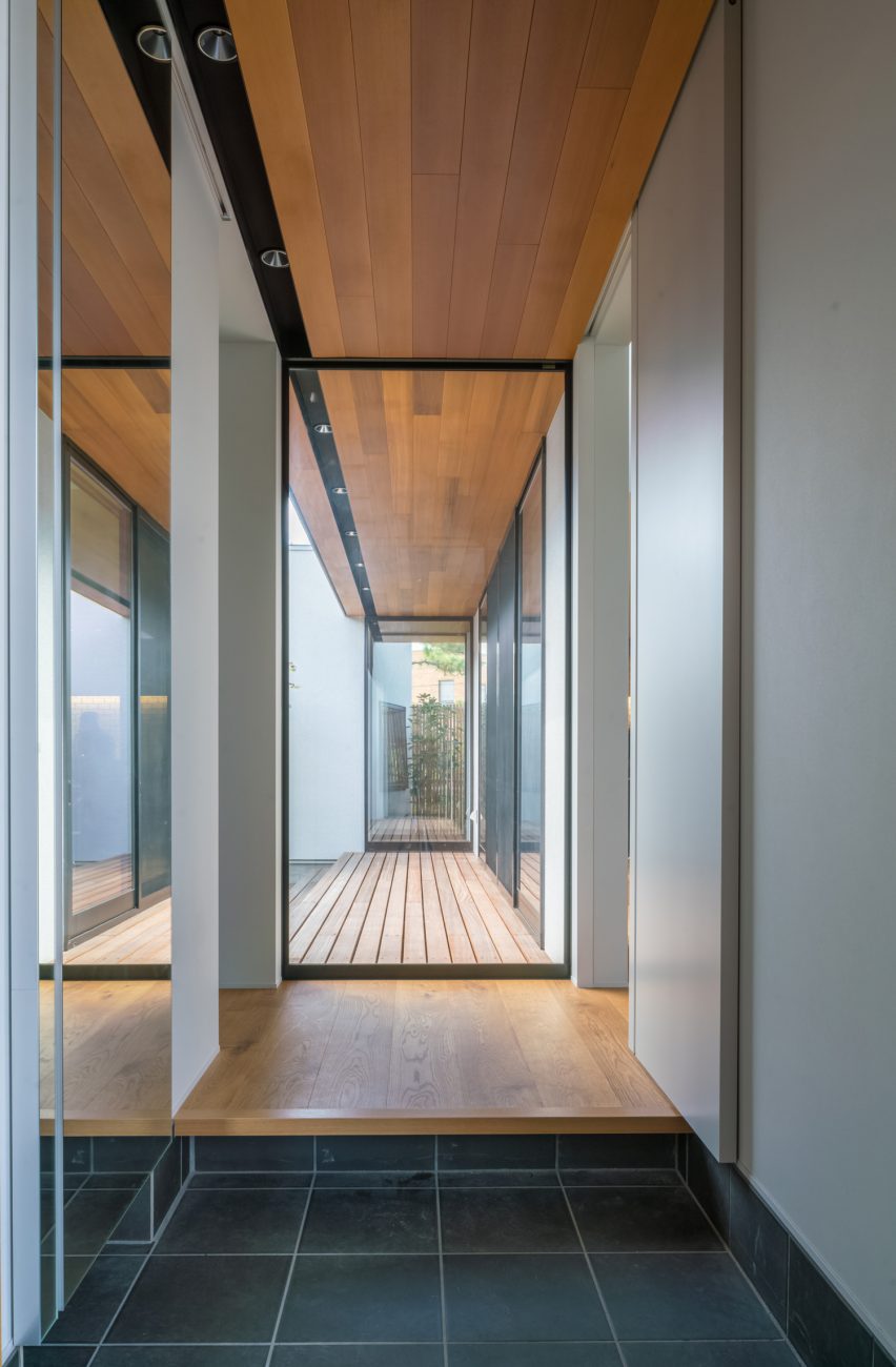 正面にウッドデッキが見えるガラス窓がある、木目の天井の玄関・デザイン住宅 注文住宅・デザイン住宅建築実例_『CASE576 回廊の家』_玄関