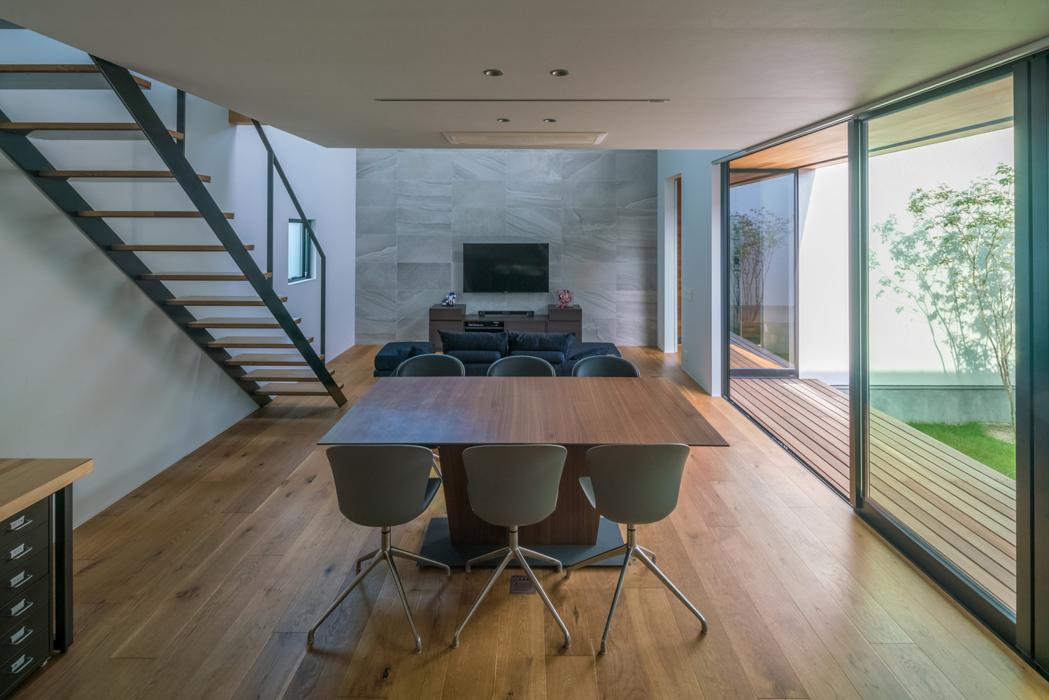 木のダイニングテーブルがあるウッドデッキ付きの中庭に面したLDK・デザイン住宅 注文住宅・デザイン住宅建築実例_『CASE576 回廊の家』_LDK