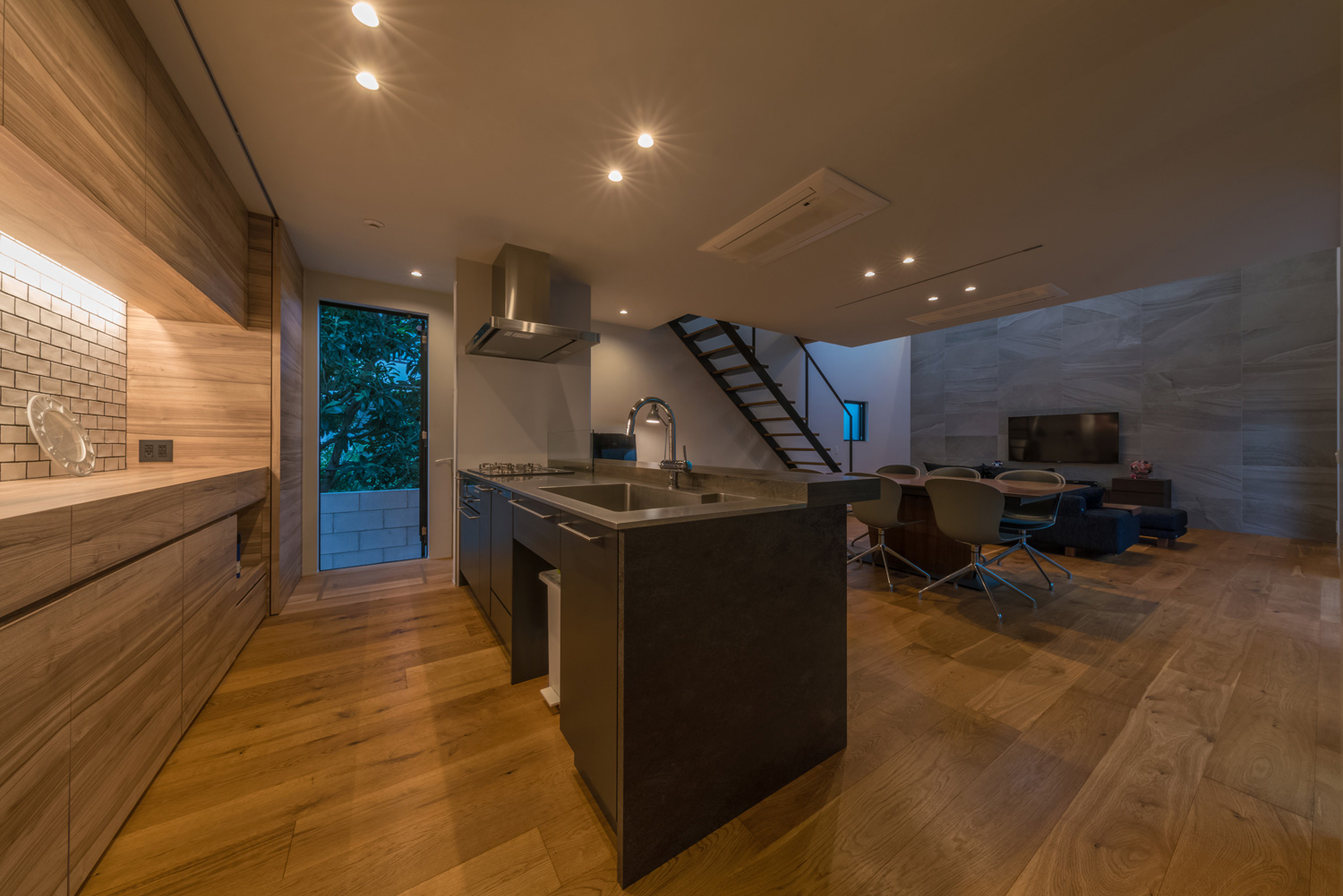 背面に木製のカップボードを取り付けた黒いペニンシュラキッチンのあるLDK・デザイン住宅 注文住宅・デザイン住宅建築実例_『CASE576 回廊の家』_LDK