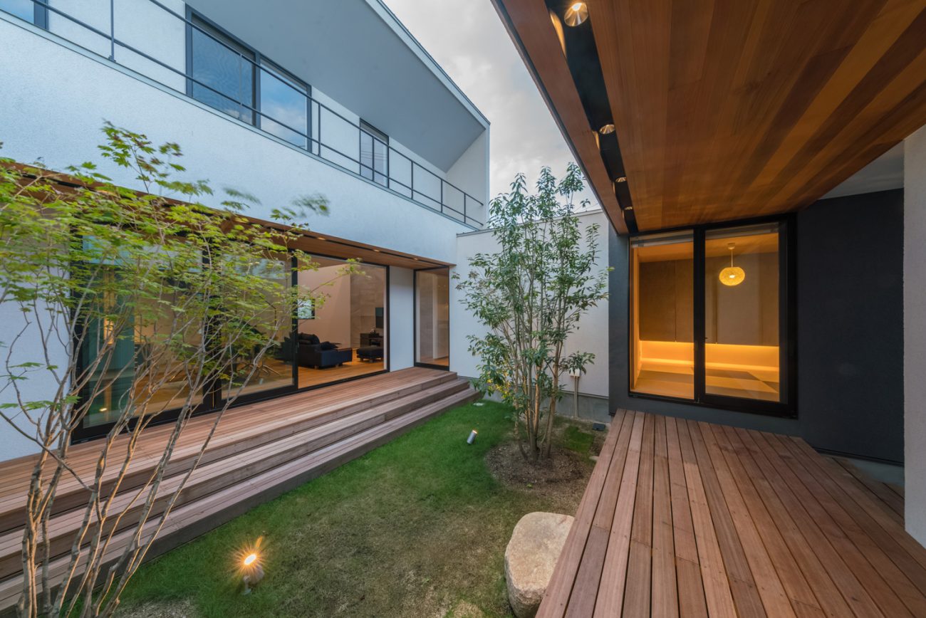 ウッドデッキ付きの芝生の中庭を囲んで部屋があるデザイン・デザイン住宅 注文住宅・デザイン住宅建築実例_『CASE576 回廊の家』_中庭