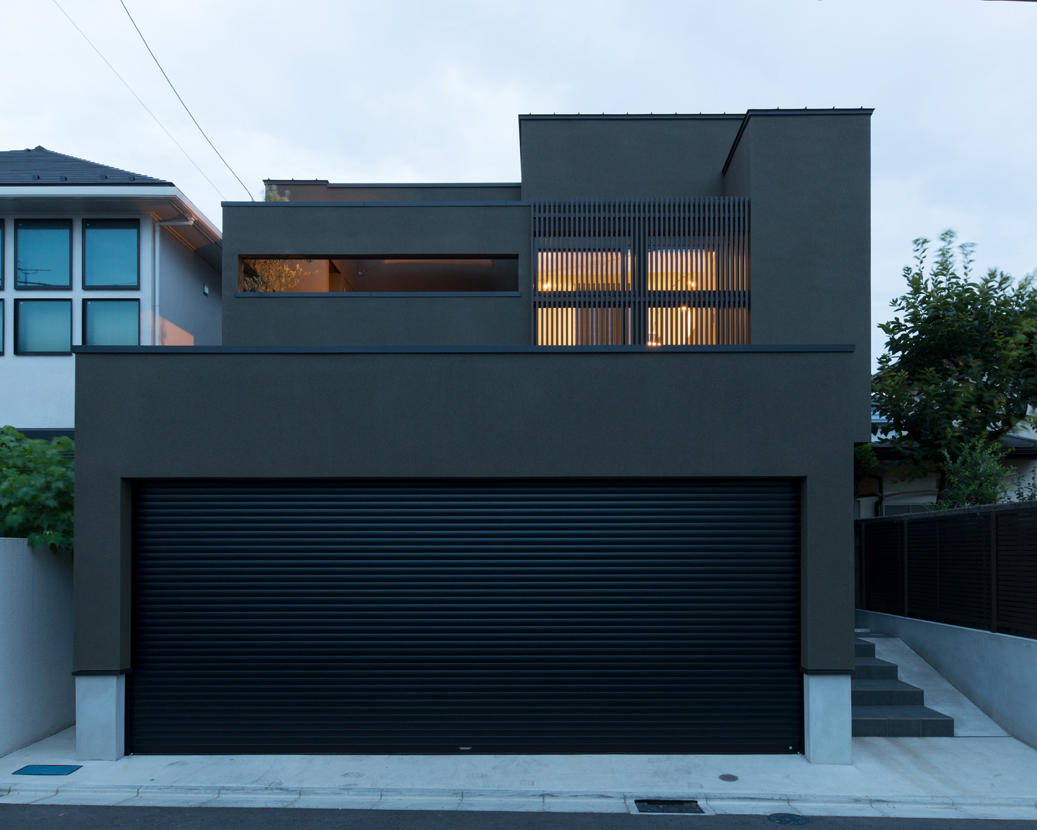 二階のベランダのルーバーの目隠しから光が漏れる外観・デザイン住宅 注文住宅・デザイン住宅建築実例_『CASE577 紬（つむぎ）の家』_外観