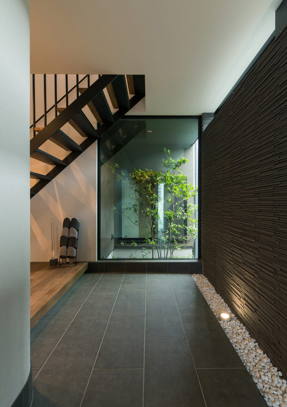 正面に植栽が見える窓があるタイルの玄関・デザイン住宅 注文住宅・デザイン住宅建築実例_『CASE577 紬（つむぎ）の家』_玄関