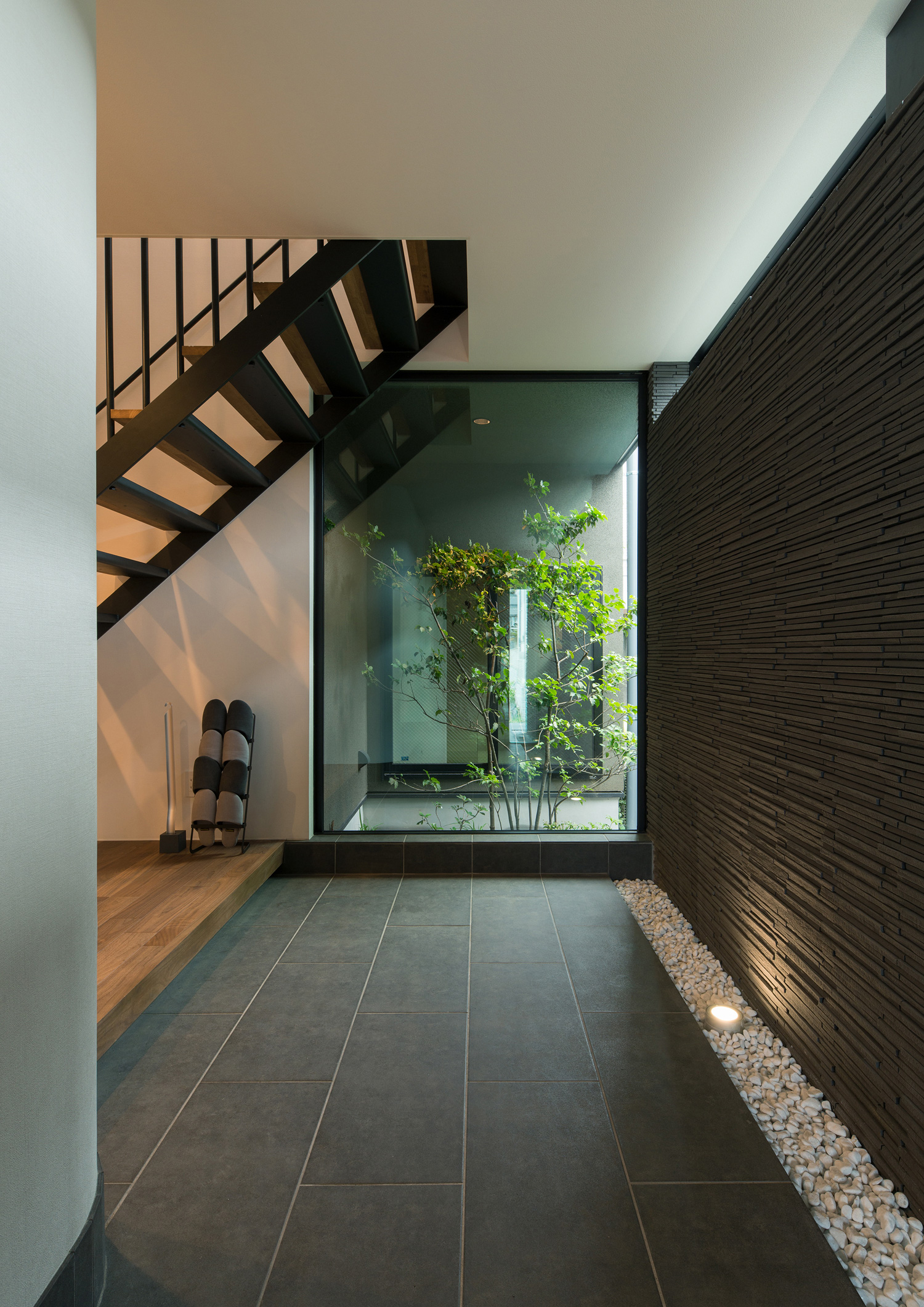 正面に植栽が見える窓があるタイルの玄関・デザイン住宅 注文住宅・デザイン住宅建築実例_『CASE577 紬（つむぎ）の家』_玄関