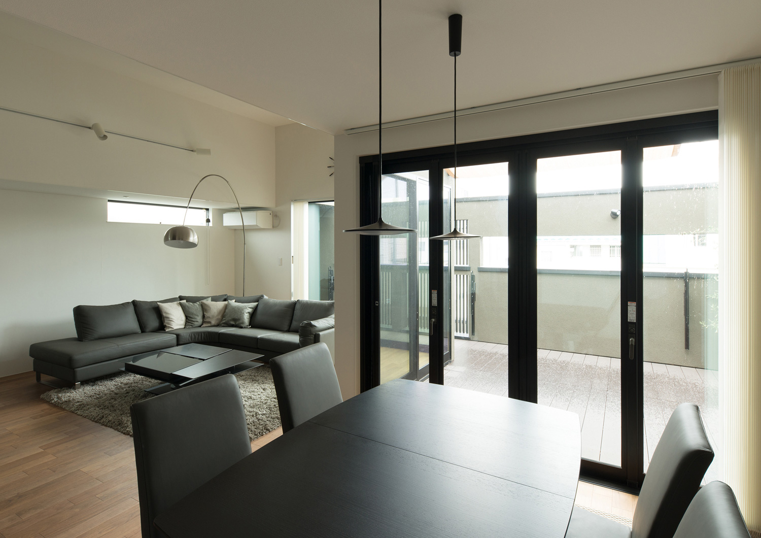 ダイニングテーブルから目隠し壁付きのバルコニーが見える様子・デザイン住宅 注文住宅・デザイン住宅建築実例_『CASE577 紬（つむぎ）の家』_LDK