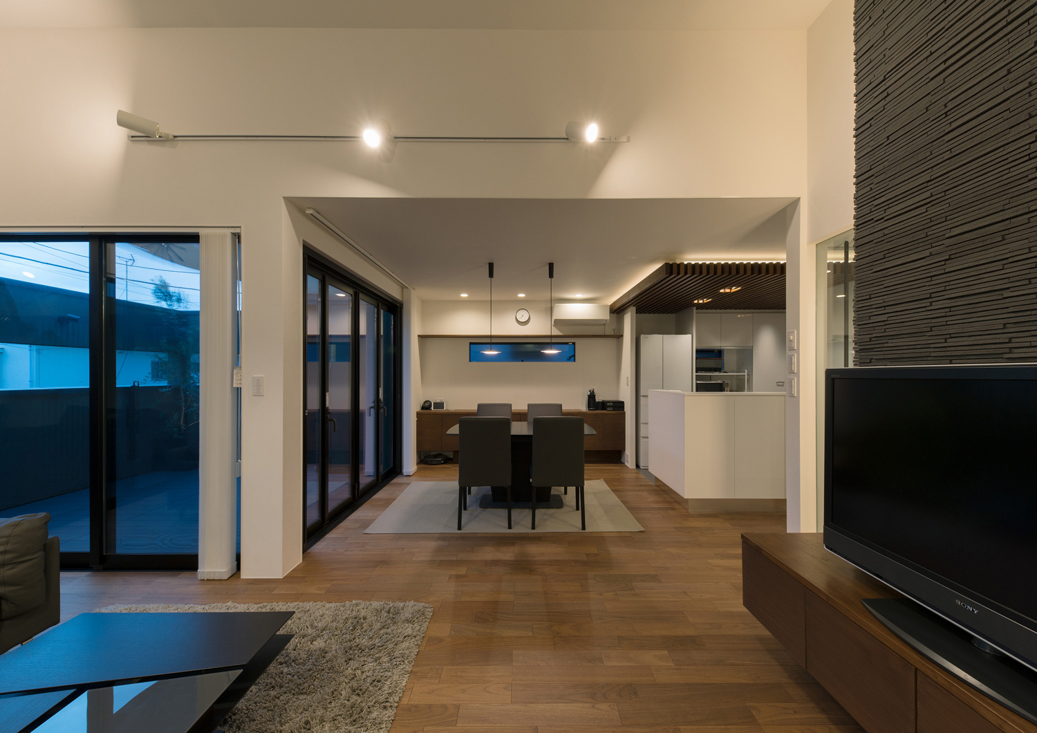 壁に白いライトレールを設けた高天井のLDK・デザイン住宅 注文住宅・デザイン住宅建築実例_『CASE577 紬（つむぎ）の家』_LDK