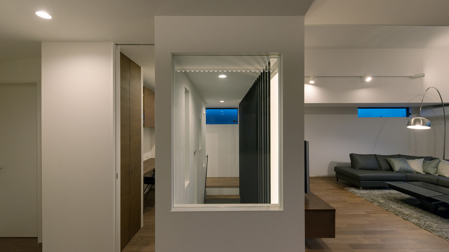 ダウンライトに照らされる、壁に一部がガラスになった階段室・デザイン住宅 注文住宅・デザイン住宅建築実例_『CASE577 紬（つむぎ）の家』_LDK