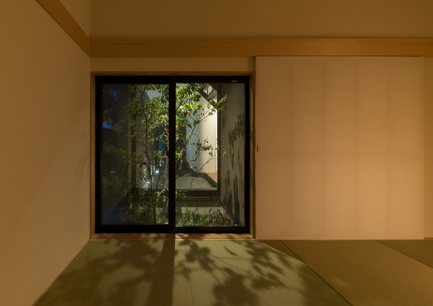 ライトアップされた植栽の影が映し出される琉球畳の和室・デザイン住宅 注文住宅・デザイン住宅建築実例_『CASE577 紬（つむぎ）の家』_和室