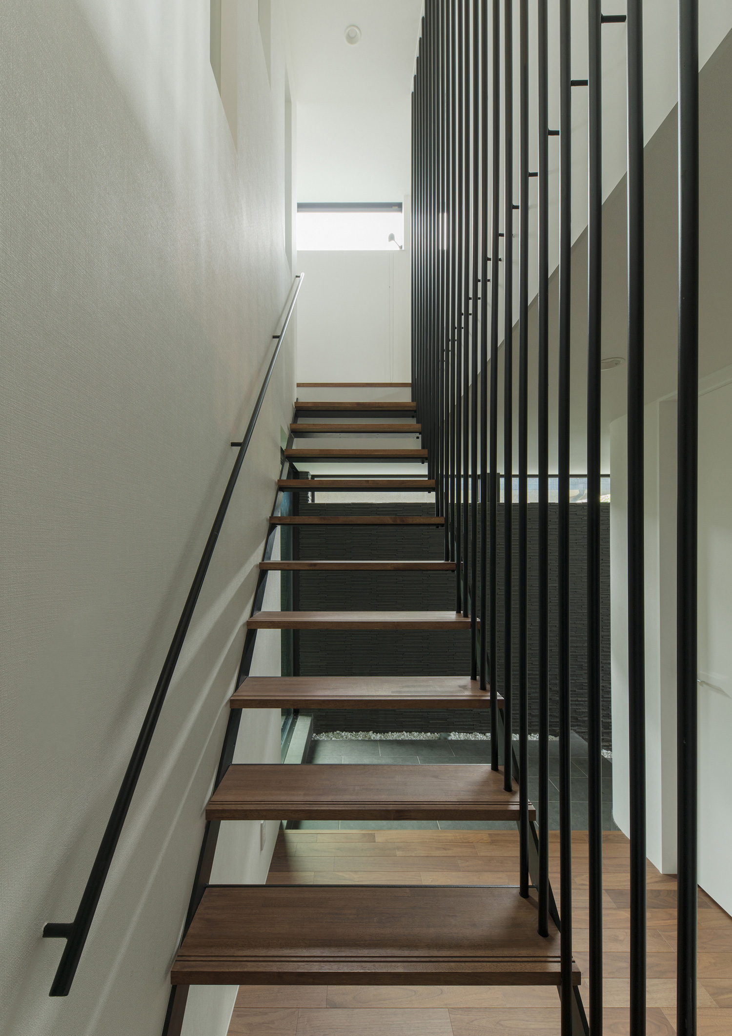 正面に小窓があるアイアンの手すり付きの木製のスケルトン階段・デザイン住宅 注文住宅・デザイン住宅建築実例_『CASE577 紬（つむぎ）の家』_階段