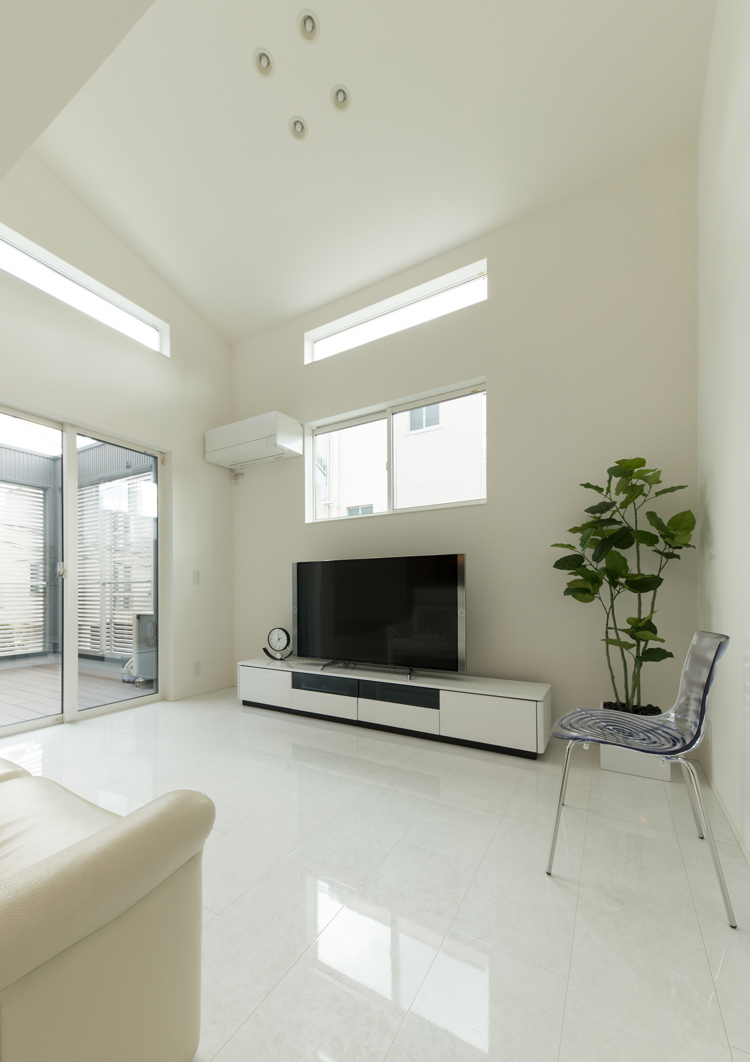 テレビの上に窓とハイサイドライトを設けた、高天井で壁と床が白いLDK・デザイン住宅 注文住宅・デザイン住宅建築実例_『CASE579 Functional House』_LDK