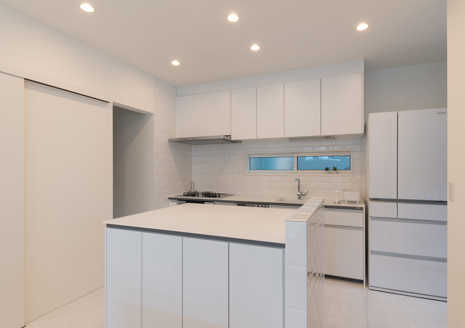 対面に作業台を設けた白で統一した壁付けキッチン・デザイン住宅 注文住宅・デザイン住宅建築実例_『CASE579 Functional House』_キッチン