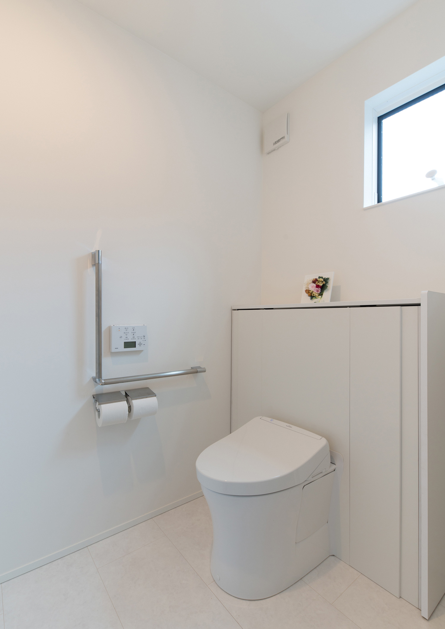 シルバーの手すりを取り付けた窓付きのトイレ・デザイン住宅 注文住宅・デザイン住宅建築実例_『CASE579 Functional House』_トイレ