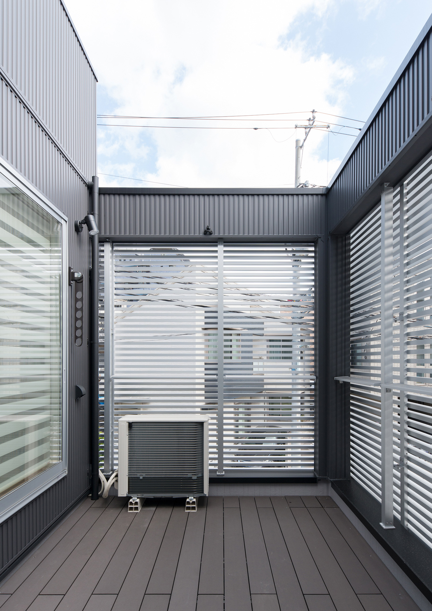 アルミのルーバーの目隠しが取り付けられたウッドデッキのバルコニー・デザイン住宅 注文住宅・デザイン住宅建築実例_『CASE579 Functional House』_テラス・バルコニー