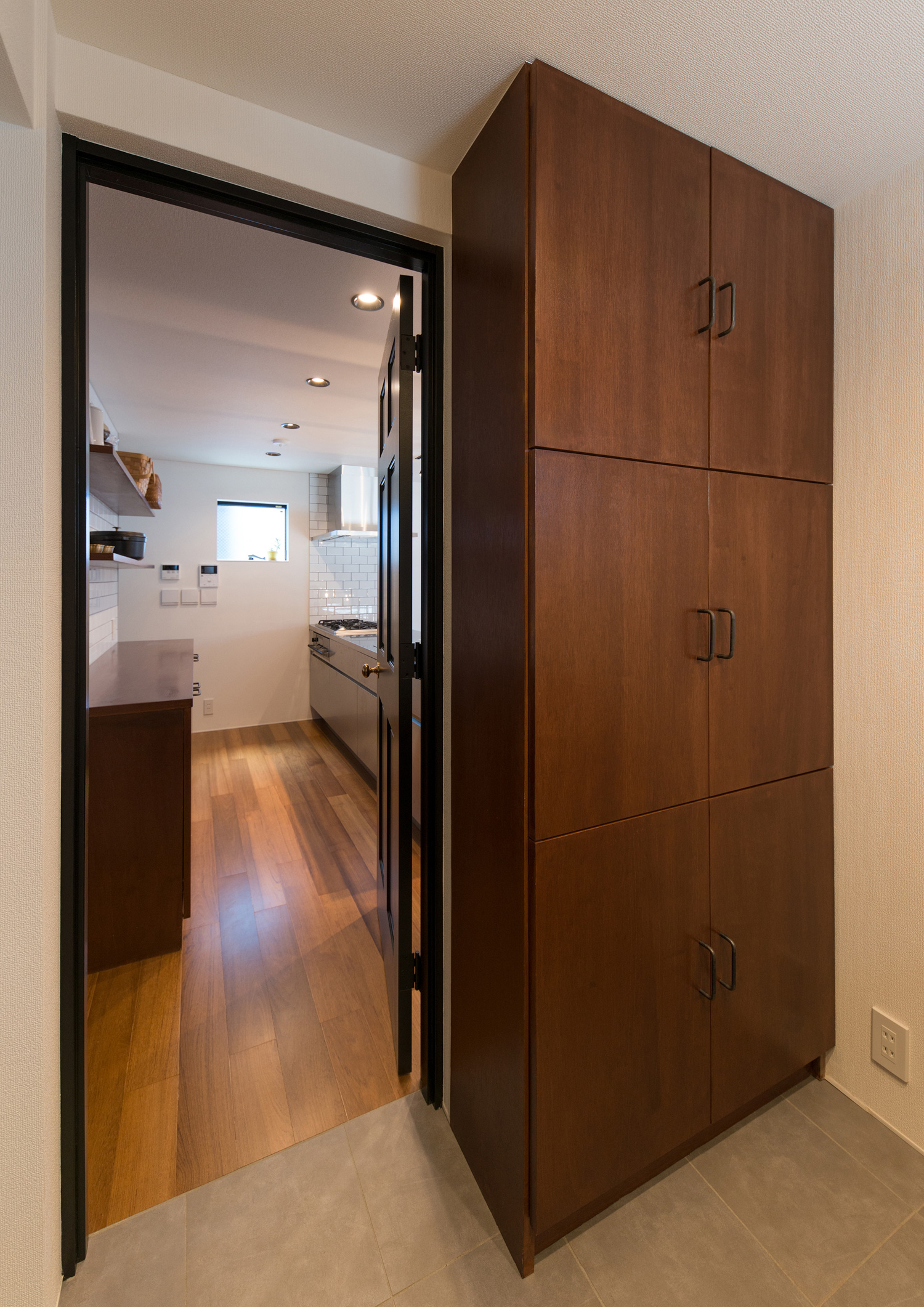 キッチンと繋がる、扉付きの木の収納棚を置いた洗面所・デザイン住宅 注文住宅・デザイン住宅建築実例_『CASE582 大切な時を刻む家』_浴室・洗面所