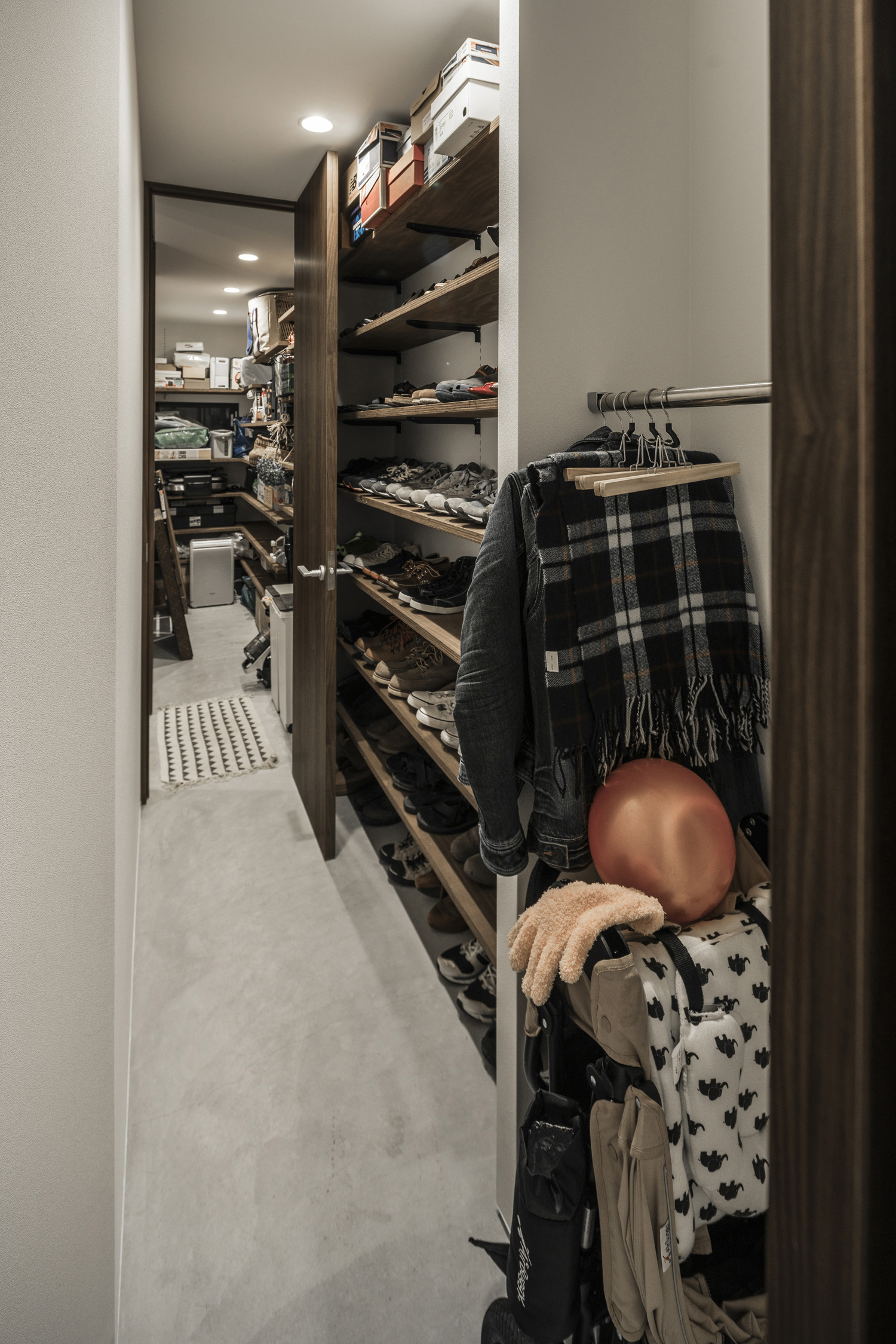 壁に棚が取り付けられた扉付きのシューズインクローゼット・デザイン住宅 注文住宅・デザイン住宅建築実例_『CASE583 デルタ』_玄関